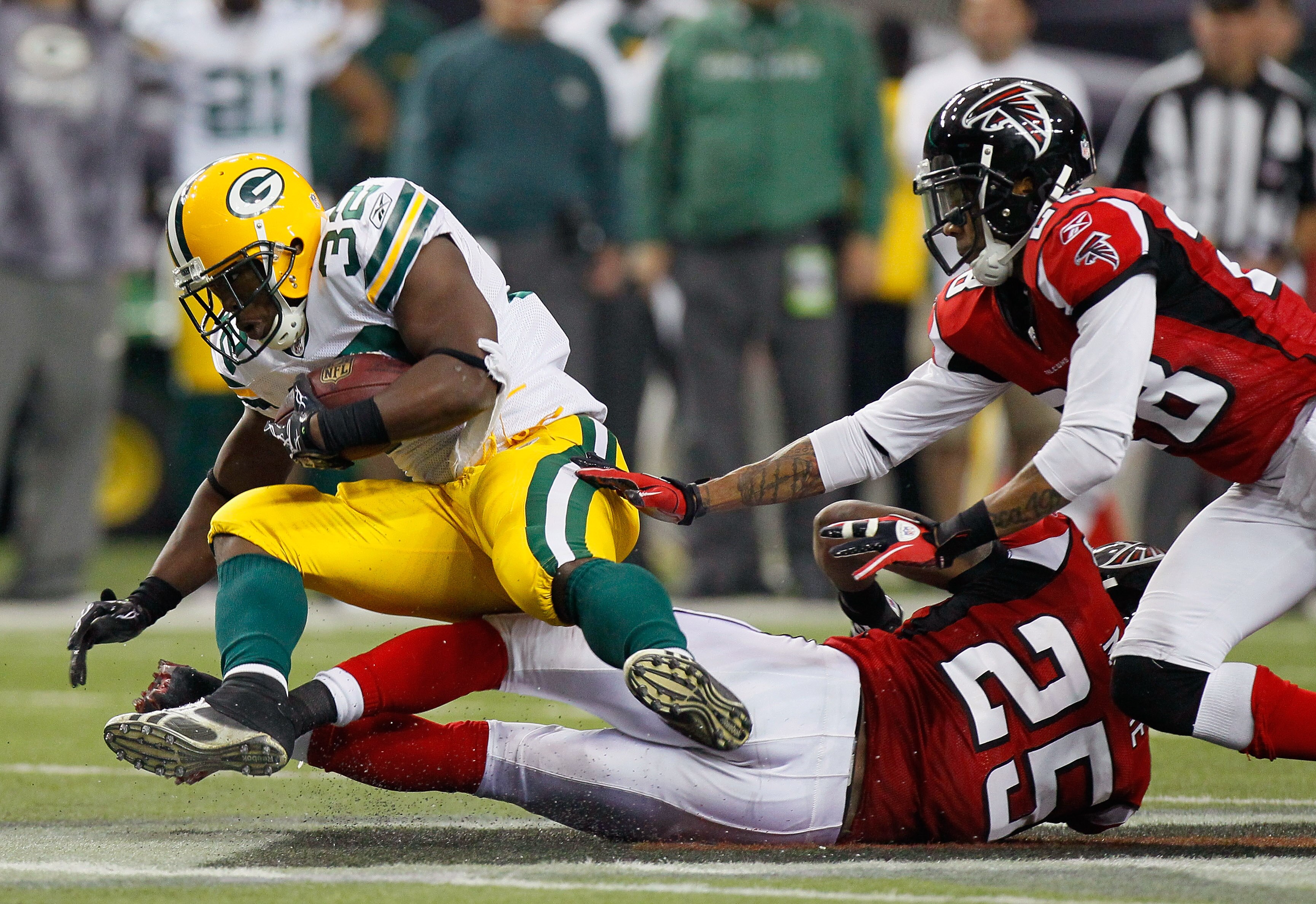 ATLANTA - NOVEMBER 28:  Thomas DeCoud #28 and William Moore #25 of the Atlanta Falcons tackle Brandon Jackson #32 of the Green Bay Packers at Georgia Dome on November 28, 2010 in Atlanta, Georgia.  (Photo by Kevin C. Cox/Getty Images)
