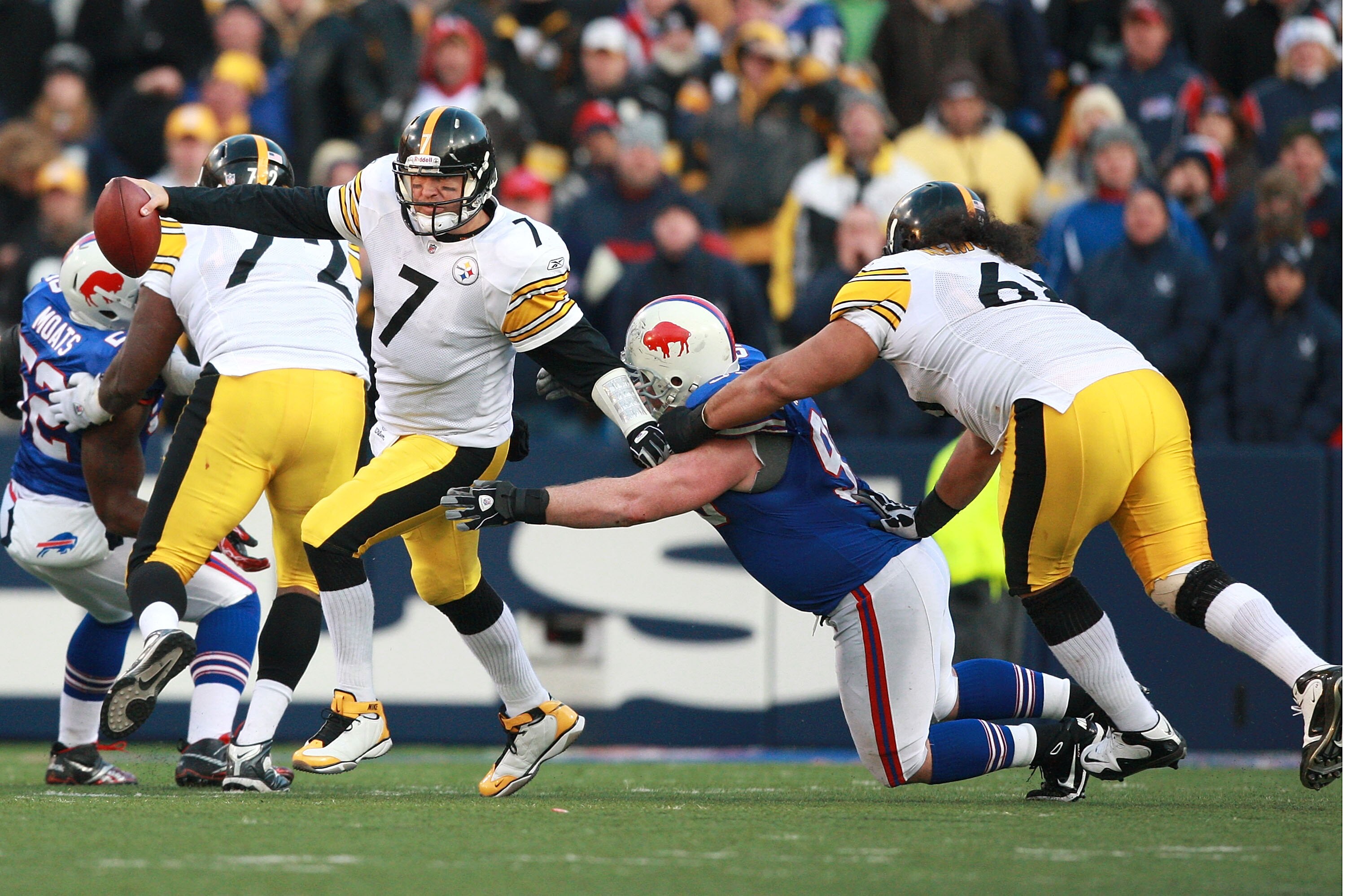 ORCHARD PARK, NY - NOVEMBER 28:  Ben Roethlisberger #7 of the Pittsburgh Steelers escapes the rush while Chris Kemoeatu #68 holds Kyle Williams #95 of the Buffalo Bills during the game at Ralph Wilson Stadium on November 28, 2010 in Orchard Park, New York