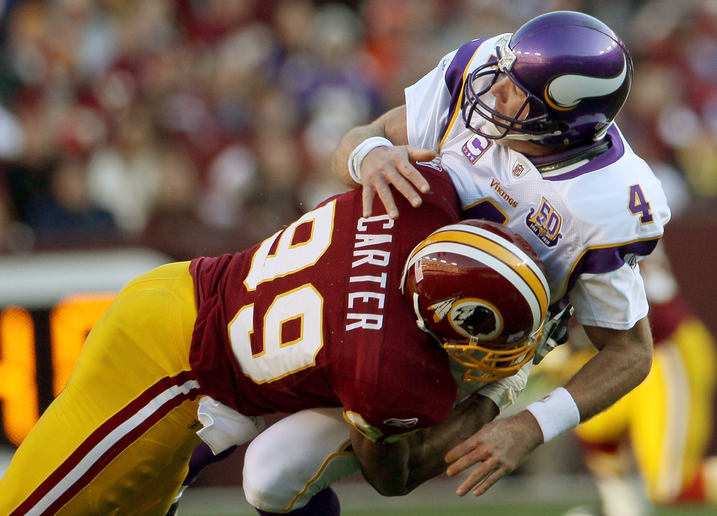 LANDOVER, MD - NOVEMBER 28:  Brett Favre #4 of the Minnesota Vikings is hit by Washington Redskins linebacker Andre Carter #99 at FedExField November 28, 2010 in Landover, Maryland. The Vikings won the game 17-13.  (Photo by Win McNamee/Getty Images)