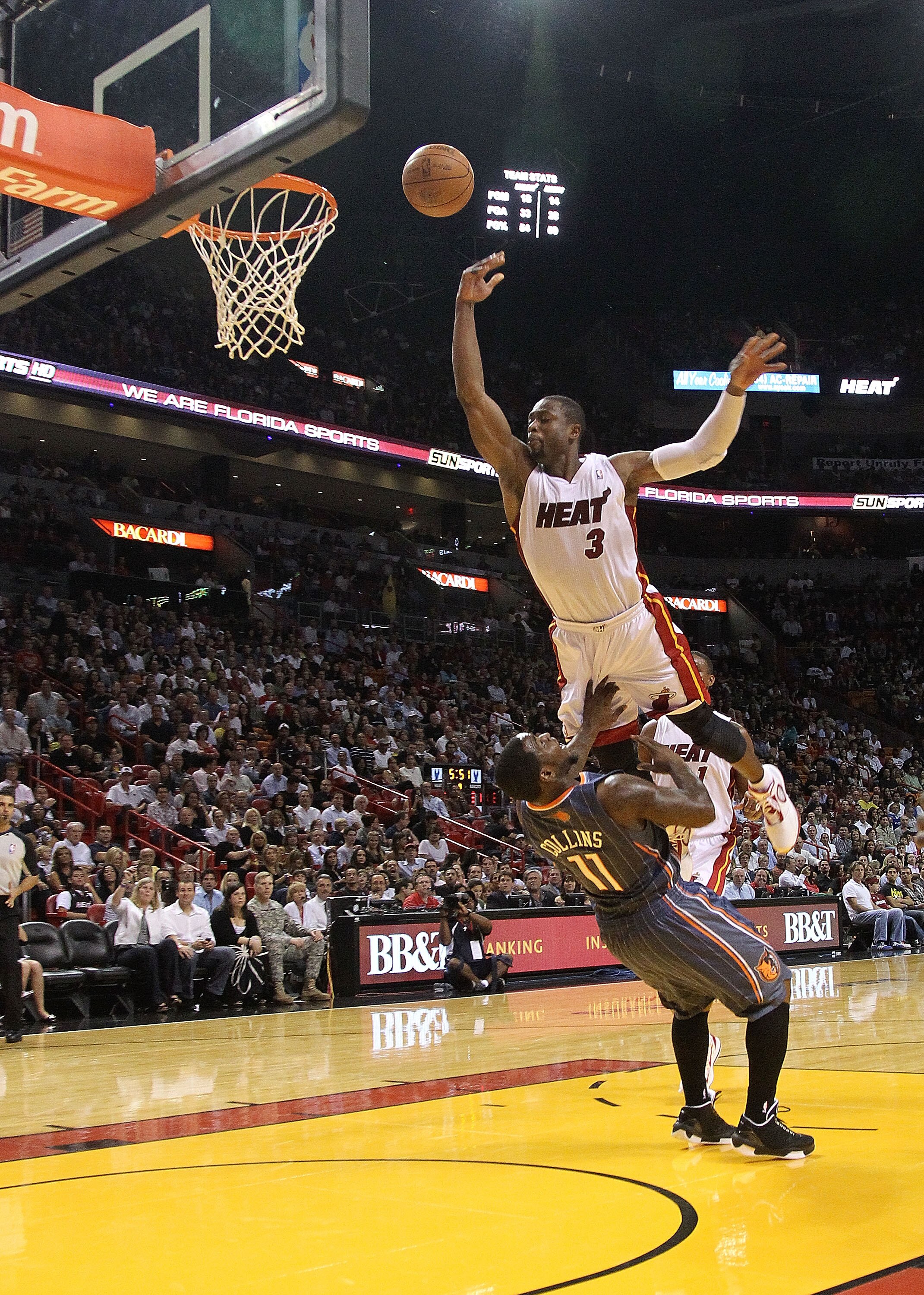 MIAMI - NOVEMBER 19:  Dwyane Wade #3 of the Miami Heat is charged with an offensive foul against Sherron Collins #11 during a game against the Charlotte Bobcats at American Airlines Arena on November 19, 2010 in Miami, Florida. NOTE TO USER: User expressl