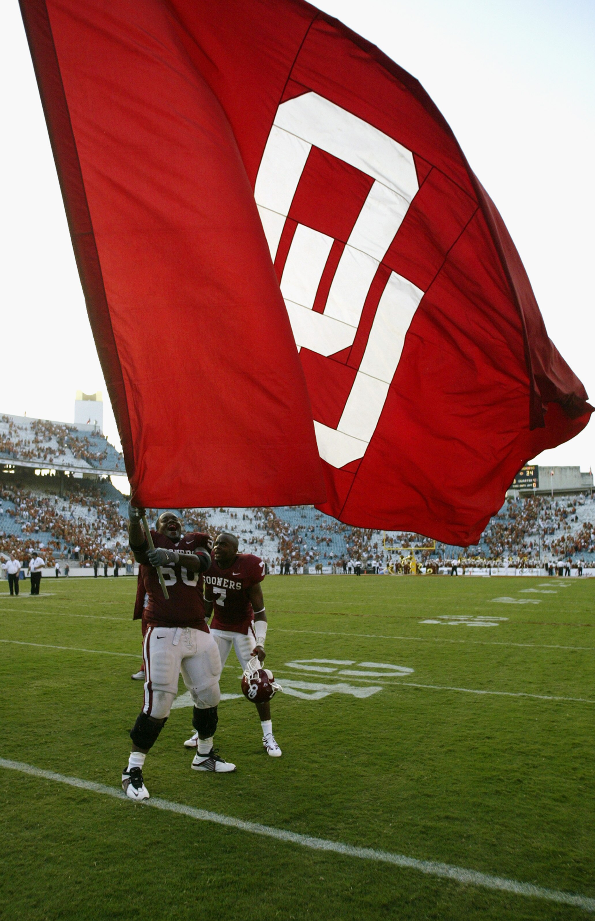 DALLAS - OCTOBER 12:  Offensive lineman Vince Carter #50 and defensive back Brandon Everage #7 of the Oklahoma Sooners celebrate victory by waving the school banner after winning the Red River Shootout against the Texas Longhorns at the Cotton Bowl on Oct