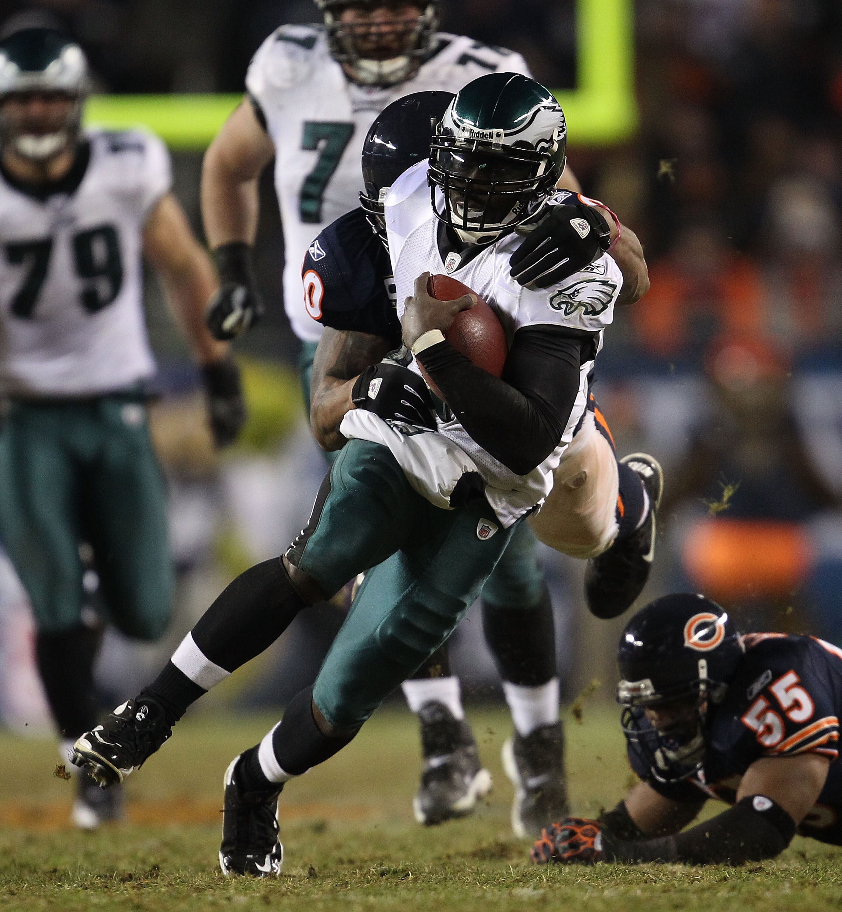 CHICAGO - NOVEMBER 28: Michael Vick #7 of the Philadelphia Eagles is brought down by Julius Peppers #90 of the Chicago Bears after breaking a tackle attempt by Lance Briggs #55 at Soldier Field on November 28, 2010 in Chicago, Illinois. The Bears defeated
