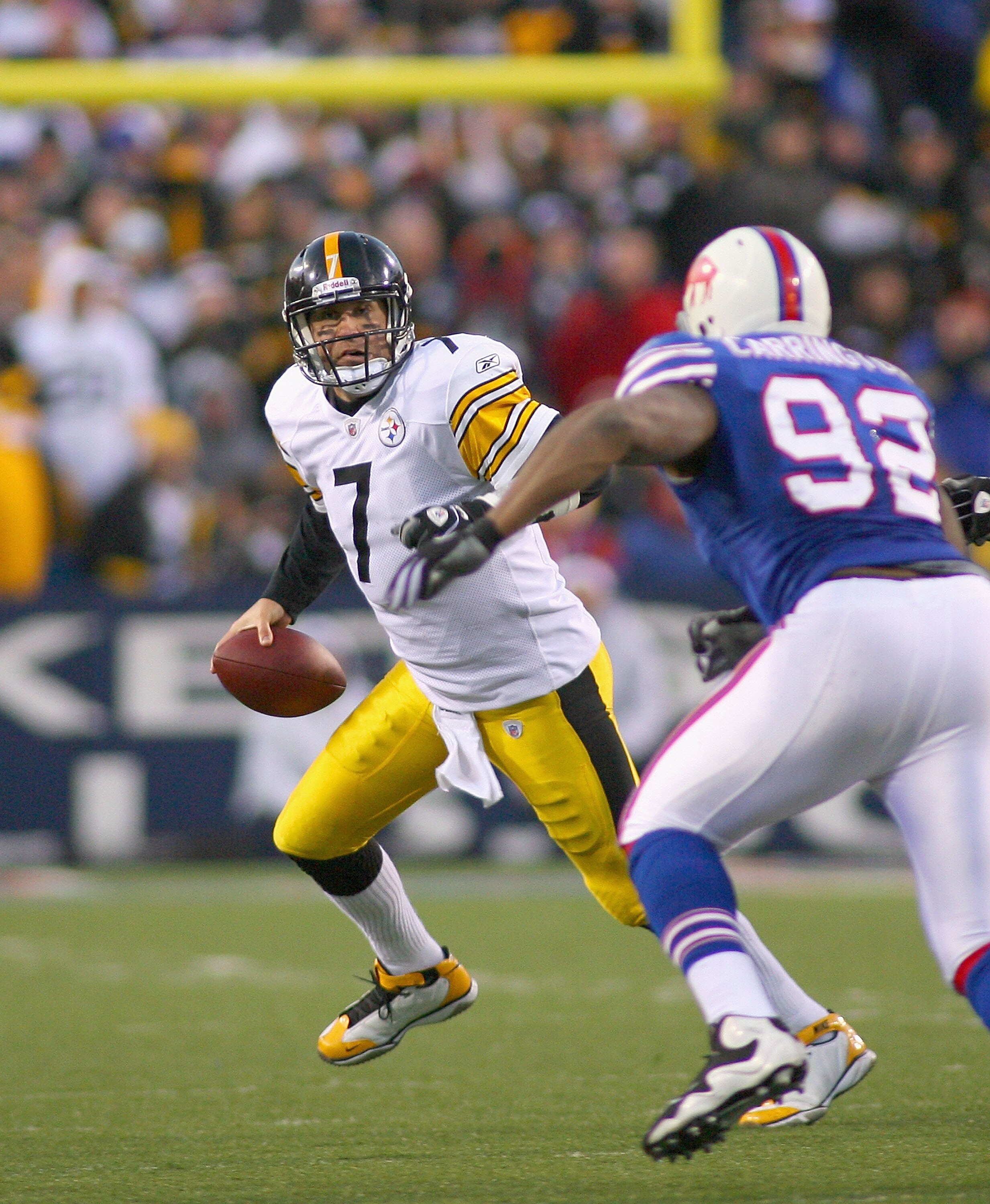 ORCHARD PARK, NY - NOVEMBER 28:  Ben Roethlisberger #7 of the Pittsburgh Steelers scrambles  with pressure from Alex Carrington #92 of  the Buffalo Bills at Ralph Wilson Stadium at Ralph Wilson Stadium on November 28, 2010 in Orchard Park, New York.  (Pho