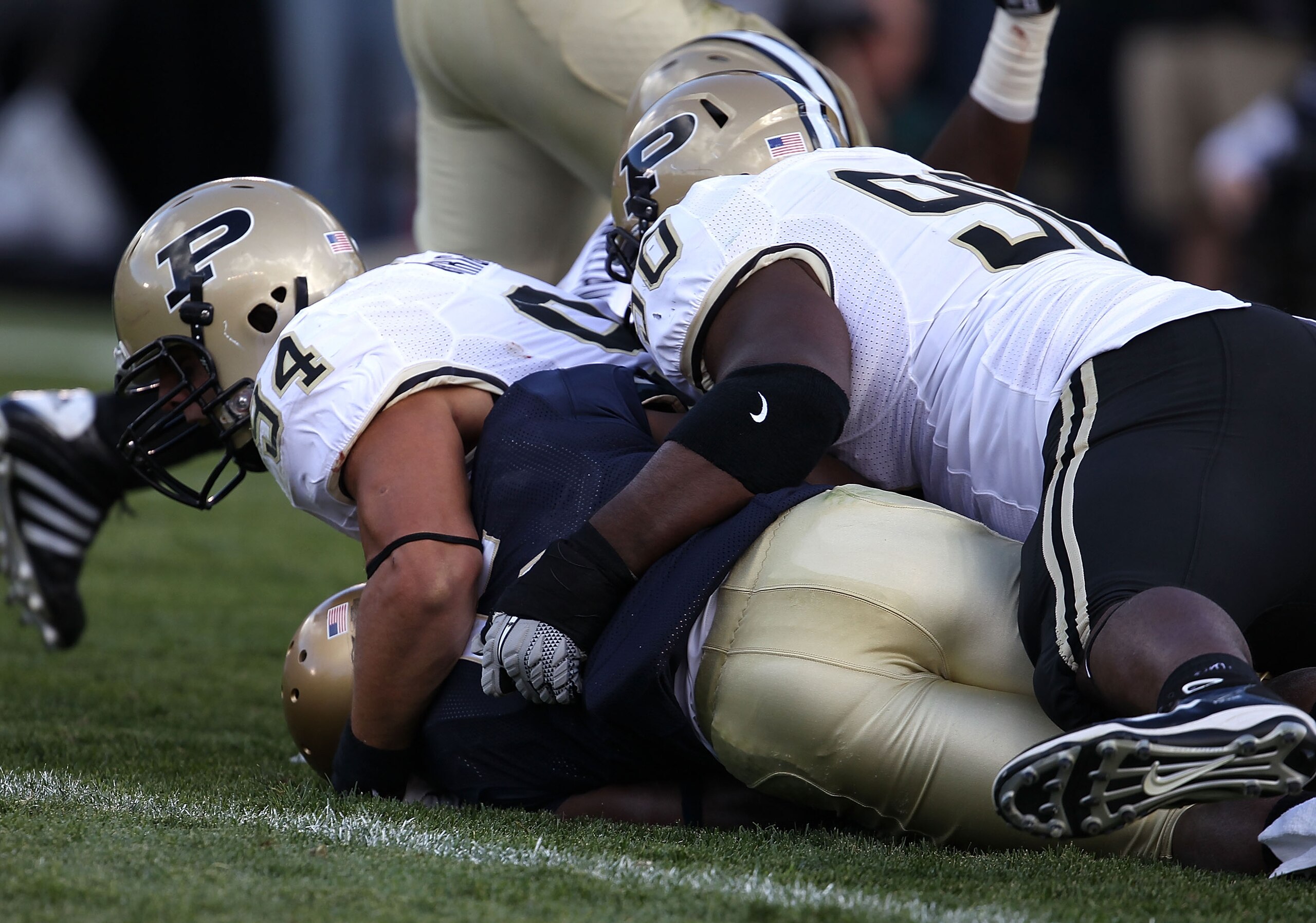SOUTH BEND, IN - SEPTEMBER 04: Armando Allen Jr., #5 of the Notre Dame Fighting Irish is tackled in the end zone for a safety by Ryan Kerrigan #94 and Bruce Gaston #90 of the Purdue Boilermakers at Notre Dame Stadium on September 4, 2010 in South Bend, In