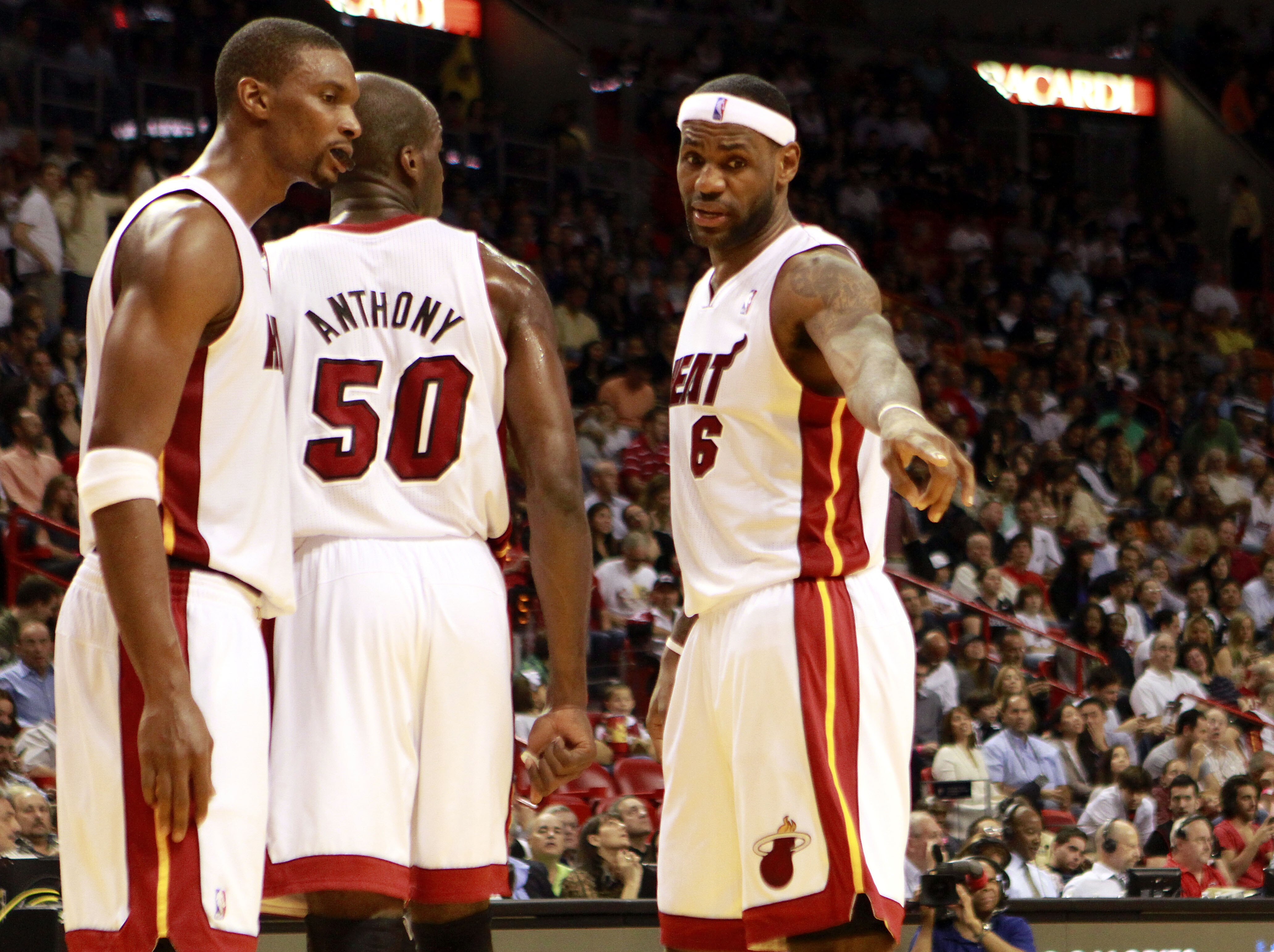 MIAMI - NOVEMBER 26:  Center Joel Anthony #50  Forward Chris Bosh #1 (L) and LeBron James #6 of the Miami Heat chat on the court against the Philadelphia 76ers at American Airlines Arena on November 26, 2010 in Miami, Florida. The Heat defeated the 76ers