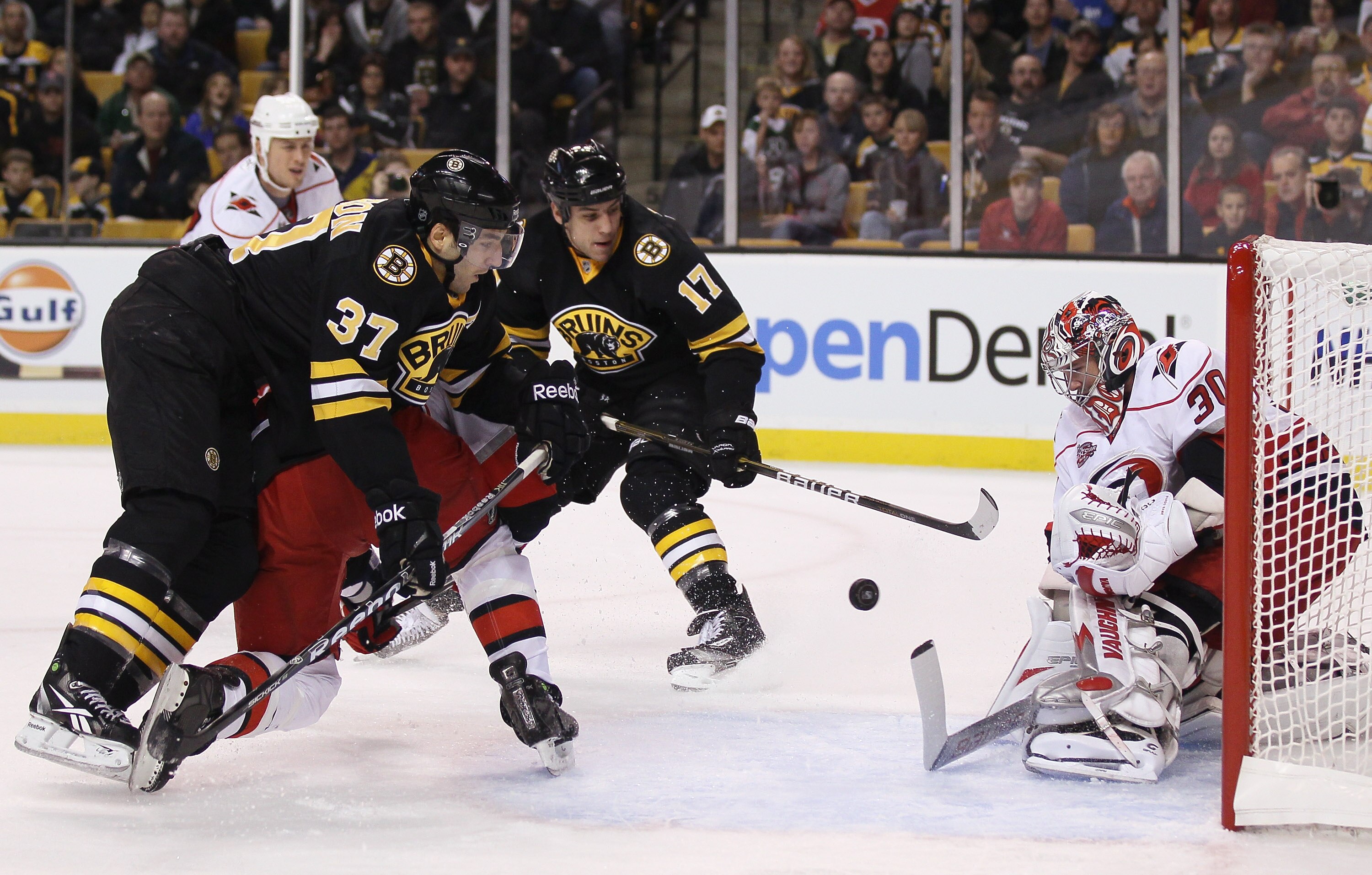 BOSTON - NOVEMBER 26:  Cam Ward #30 of the Carolina Hurricanes stops a shot by Patrice Bergeron #37 of the Boston Bruins on November 26, 2010 at the TD Garden in Boston, Massachusetts. Milan Lucic #17 of the Bruins waits for the rebound. (Photo by Elsa/Ge