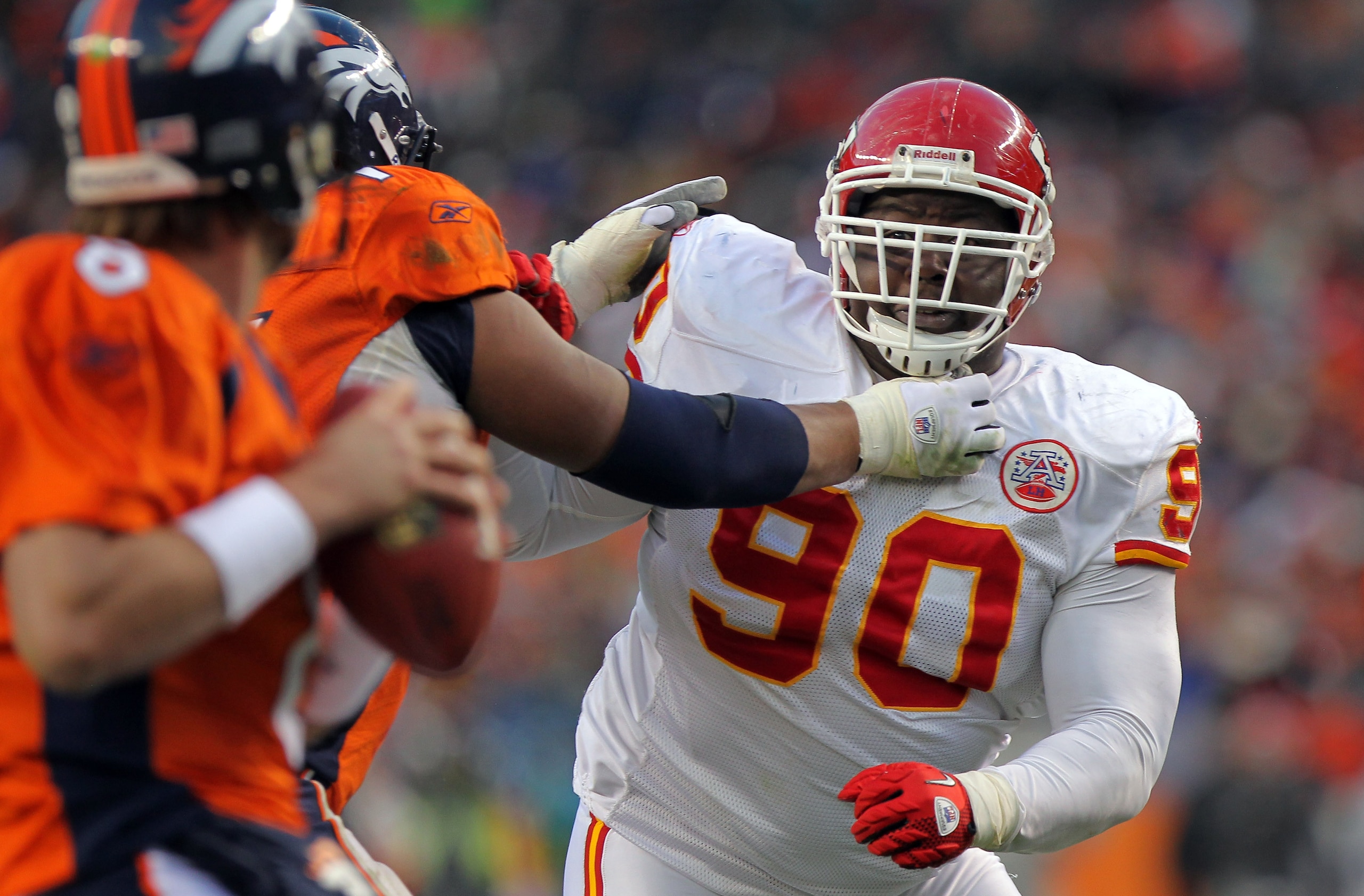 DENVER - NOVEMBER 14:  Defensive tackle Shaun Smith #90 of the Kansas City Chiefs rushes quarterback Kyle Orton against the protection of offensive lineman Ryan Harris #74 of the Denver Bronco at INVESCO Field at Mile High on November 14, 2010 in Denver, 