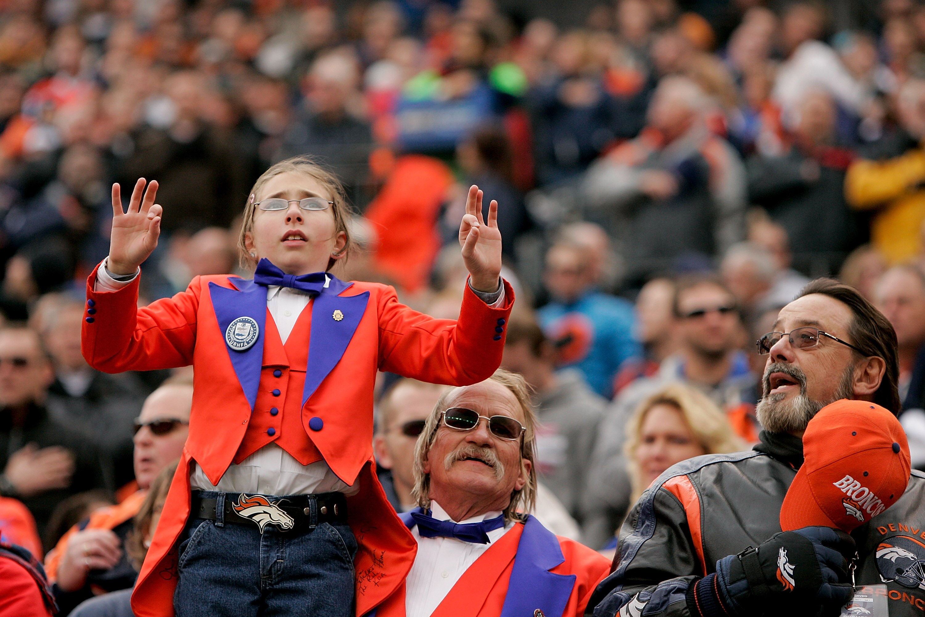 DENVER - NOVEMBER 28:  Courtney Hocking, 9, of Pueblo preforms the National Anthem in sign language while standing with her grandfather Jay Hocking (C) before an NFL game between the Denver Broncos and St. Louis Rams at INVESCO Field at Mile High on Novem