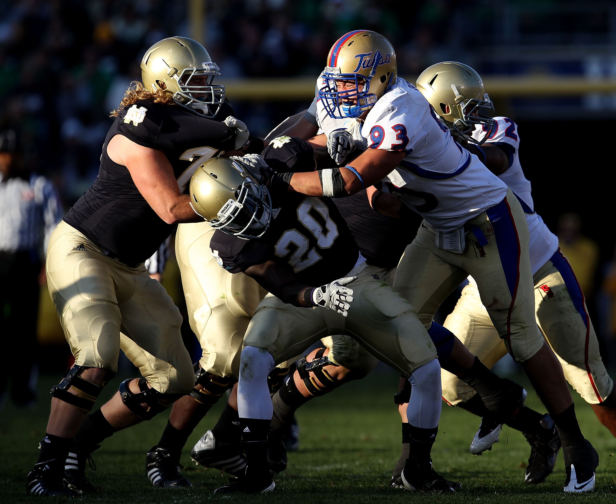 SOUTH BEND, IN - OCTOBER 30: Cory Dorris #93 of the Tulsa Golden Hurricane takes on Taylor Dever #75 and Cierre Wood #20 of the Notre Dame Fighting Irish at Notre Dame Stadium on October 30, 2010 in South Bend, Indiana. Tulsa defeated Notre Dame 28-27. (P
