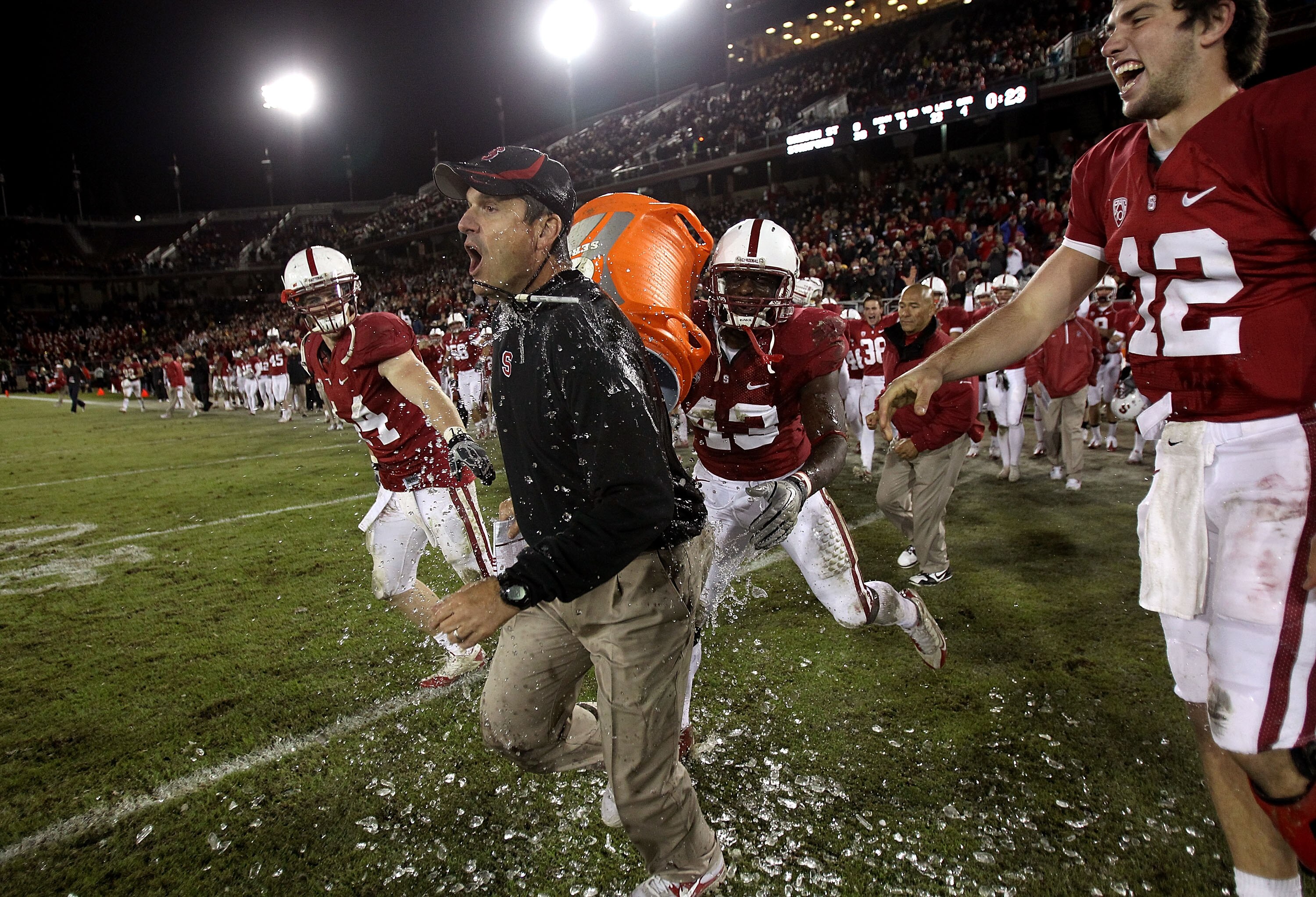 PALO ALTO, CA - NOVEMBER 27:  Head coach Jim Harbaugh of the Stanford Cardinal is covered with water from a Gatorade cooler by Andrew Luck #12 and Chike Amajoyi #43 after the Cardinal beat the Oregon State Beavers at Stanford Stadium on November 27, 2010