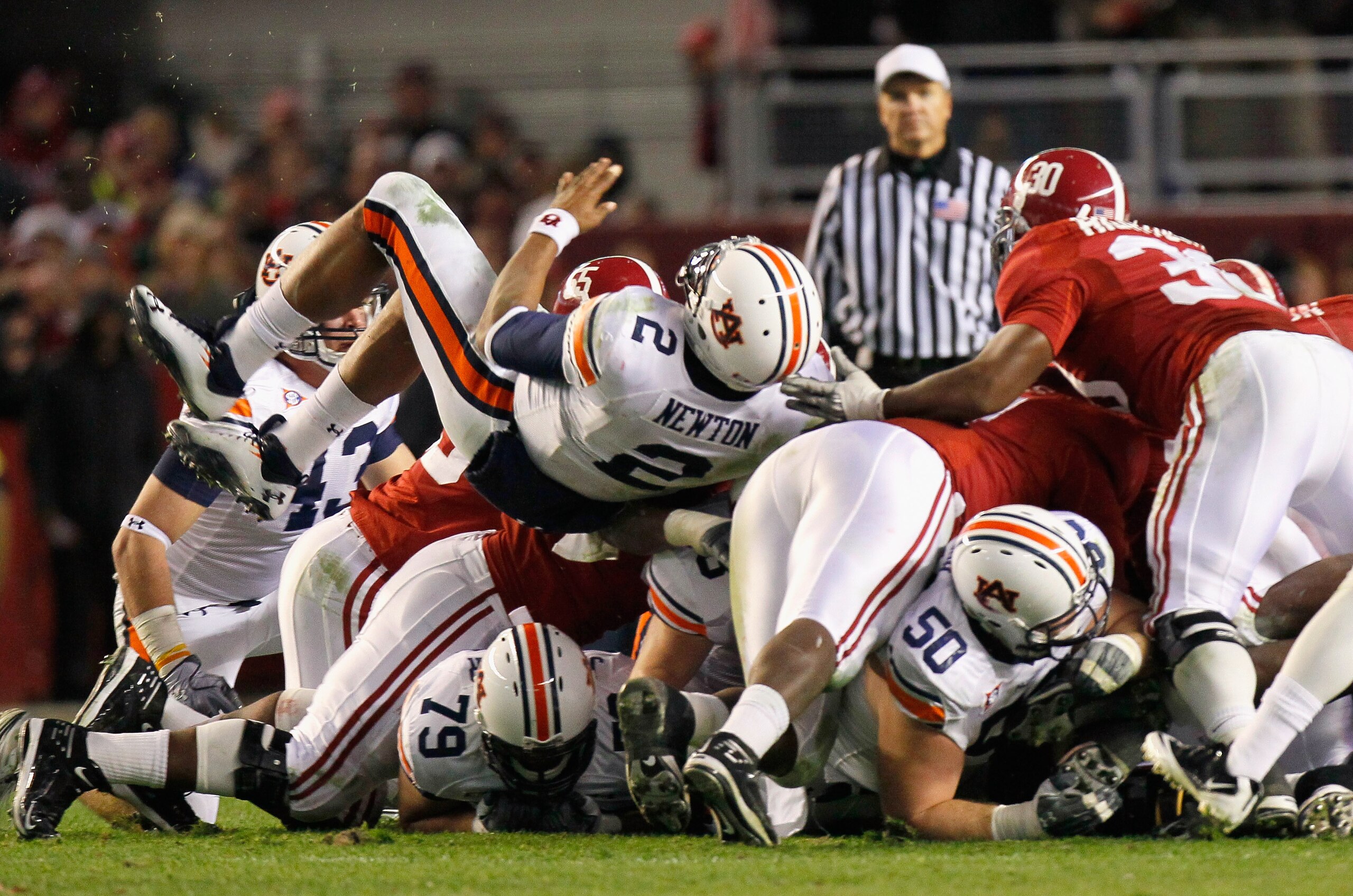 TUSCALOOSA, AL - NOVEMBER 26:  Quarterback Cam Newton #2 of the Auburn Tigers dives and rolls over the defense of the Alabama Crimson Tide for a first down at Bryant-Denny Stadium on November 26, 2010 in Tuscaloosa, Alabama.  (Photo by Kevin C. Cox/Getty 