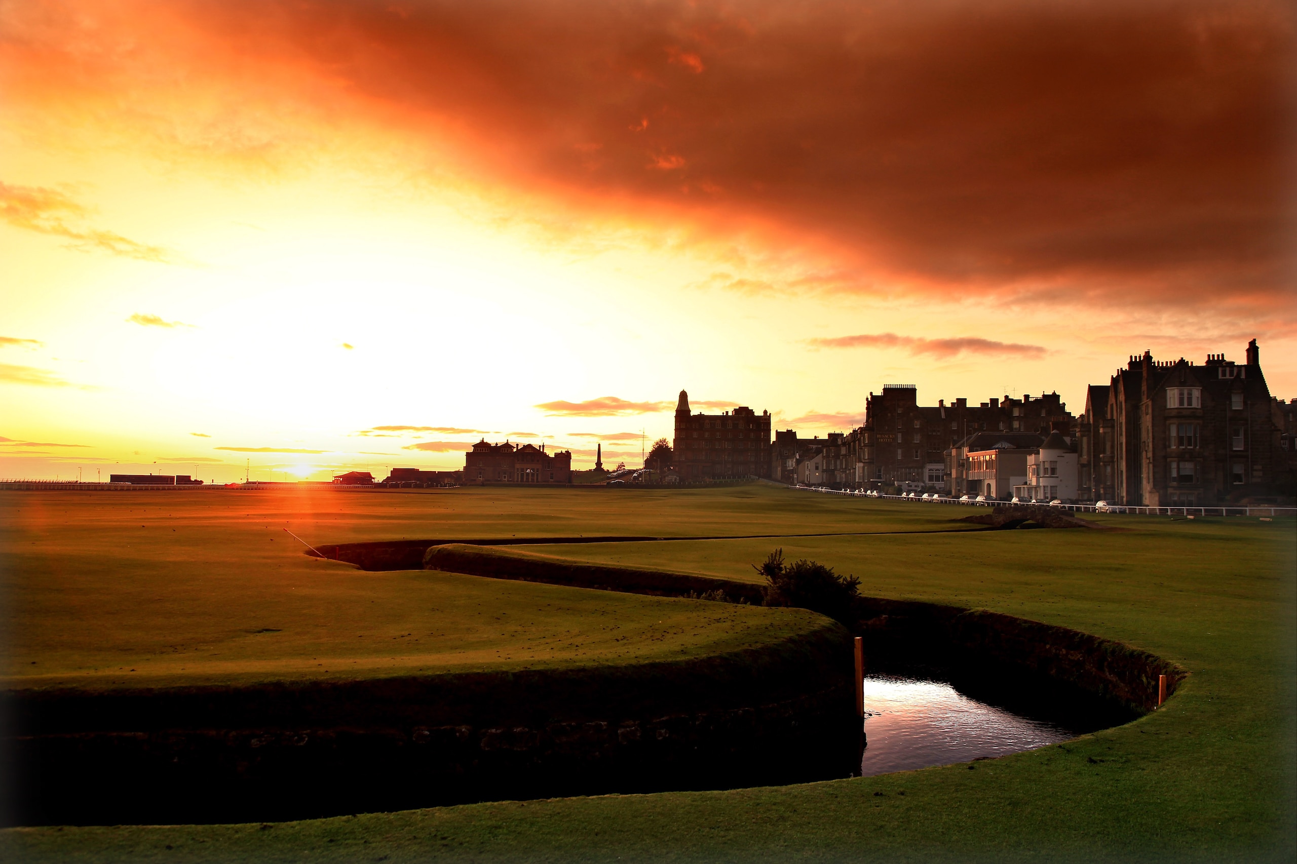 ST ANDREWS, UNITED KINGDOM - AUGUST 29:  The sun rises behind the R&A Clubhouse on the par 4, 18th hole 'Tom Morris' on the Old Course at St Andrews on August 29, 2009 in St Andrews, Scotland  (Photo by David Cannon/Getty Images)
