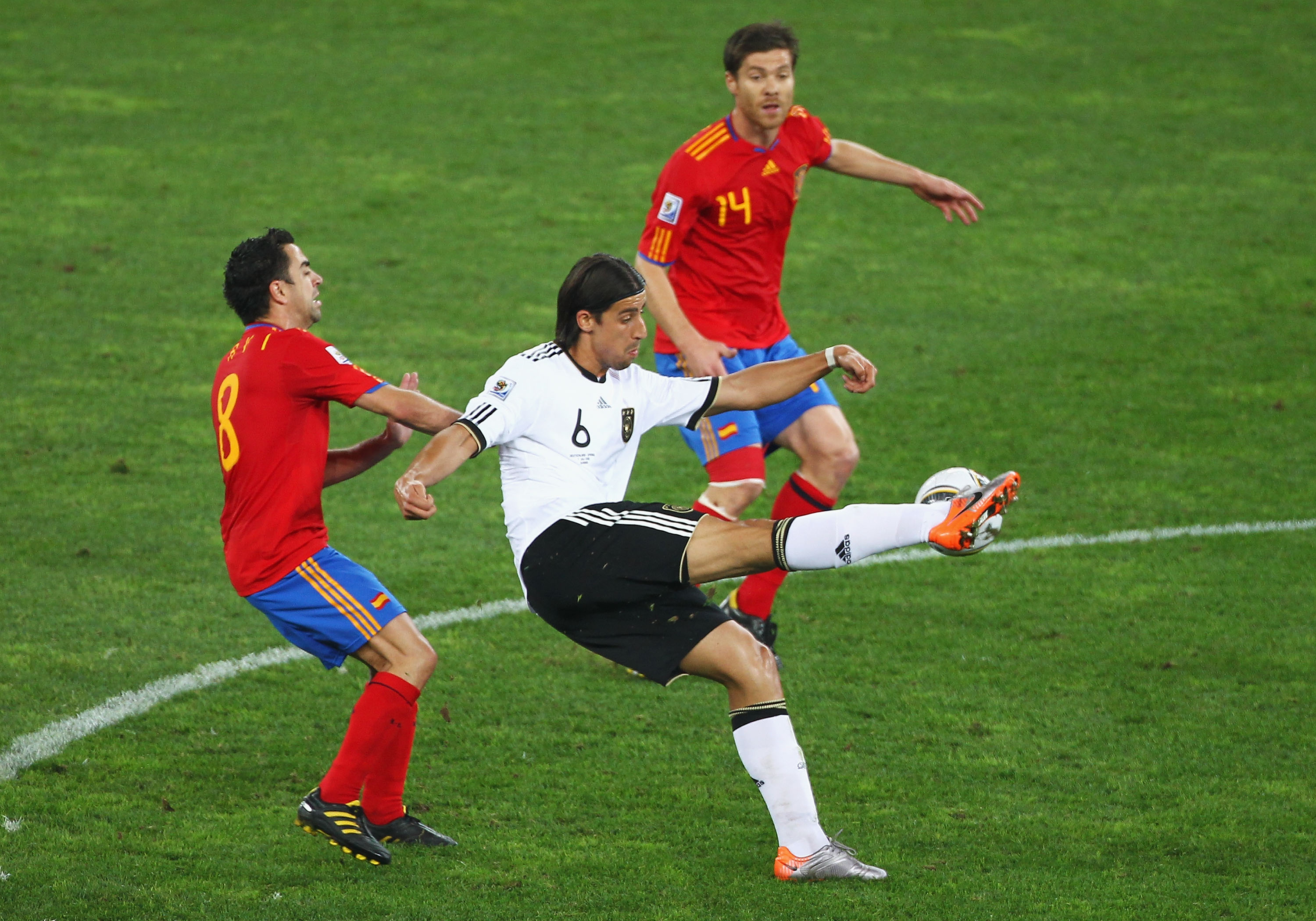 DURBAN, SOUTH AFRICA - JULY 07:  Xavi Hernandez and Xabi Alonso of Spain challenge Sami Khedira of Germany during the 2010 FIFA World Cup South Africa Semi Final match between Germany and Spain at Durban Stadium on July 7, 2010 in Durban, South Africa.  (