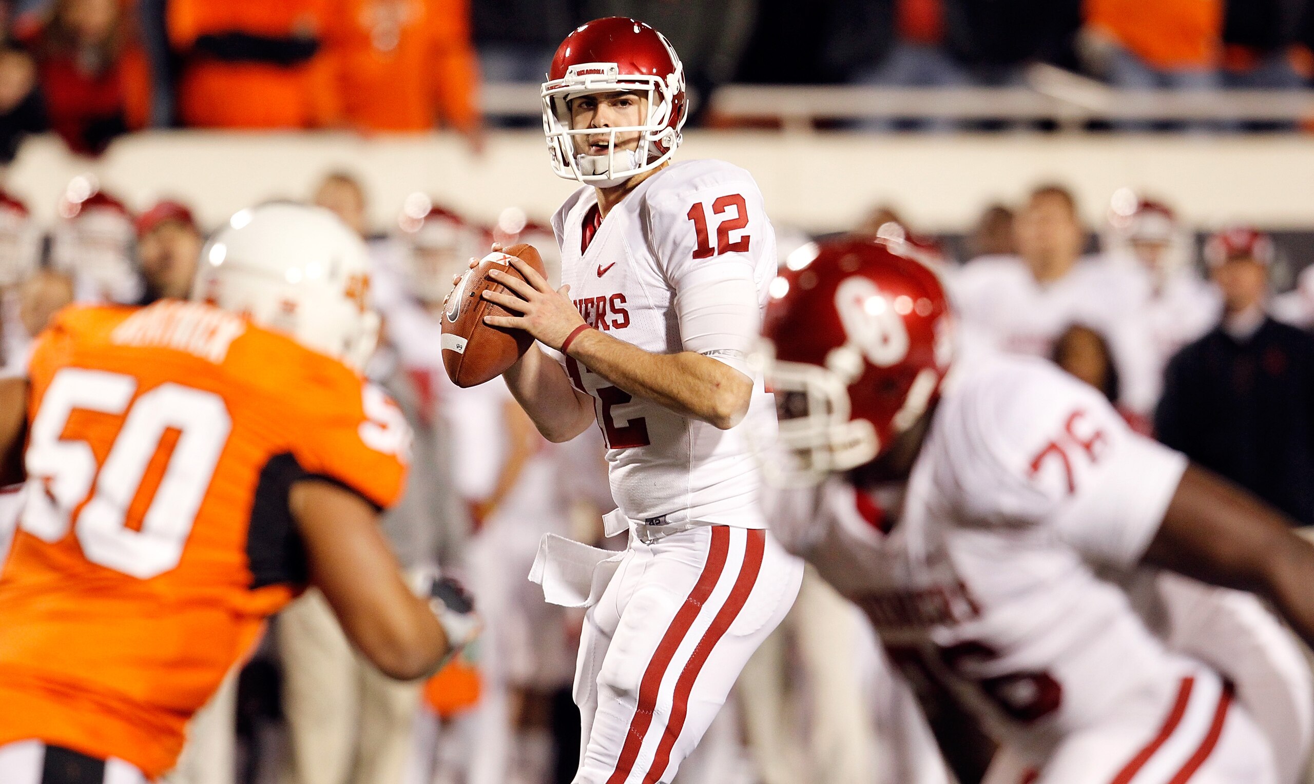 STILLWATER, OK - NOVEMBER 27: Quarterback Landry Jones #12 of the Oklahoma Sooners looks for an open receiver against the Oklahoma State Cowboys at Boone Pickens Stadium on November 27, 2010 in Stillwater, Oklahoma. (Photo by Tom Pennington/Getty Images STILLWATER, OK - NOVEMBER 27: Quarterback Landry Jones #12 of the Oklahoma Sooners looks for an open receiver against the Oklahoma State Cowboys at Boone Pickens Stadium on November 27, 2010 in Stillwater, Oklahoma. (Photo by Tom Pennington/Getty Images