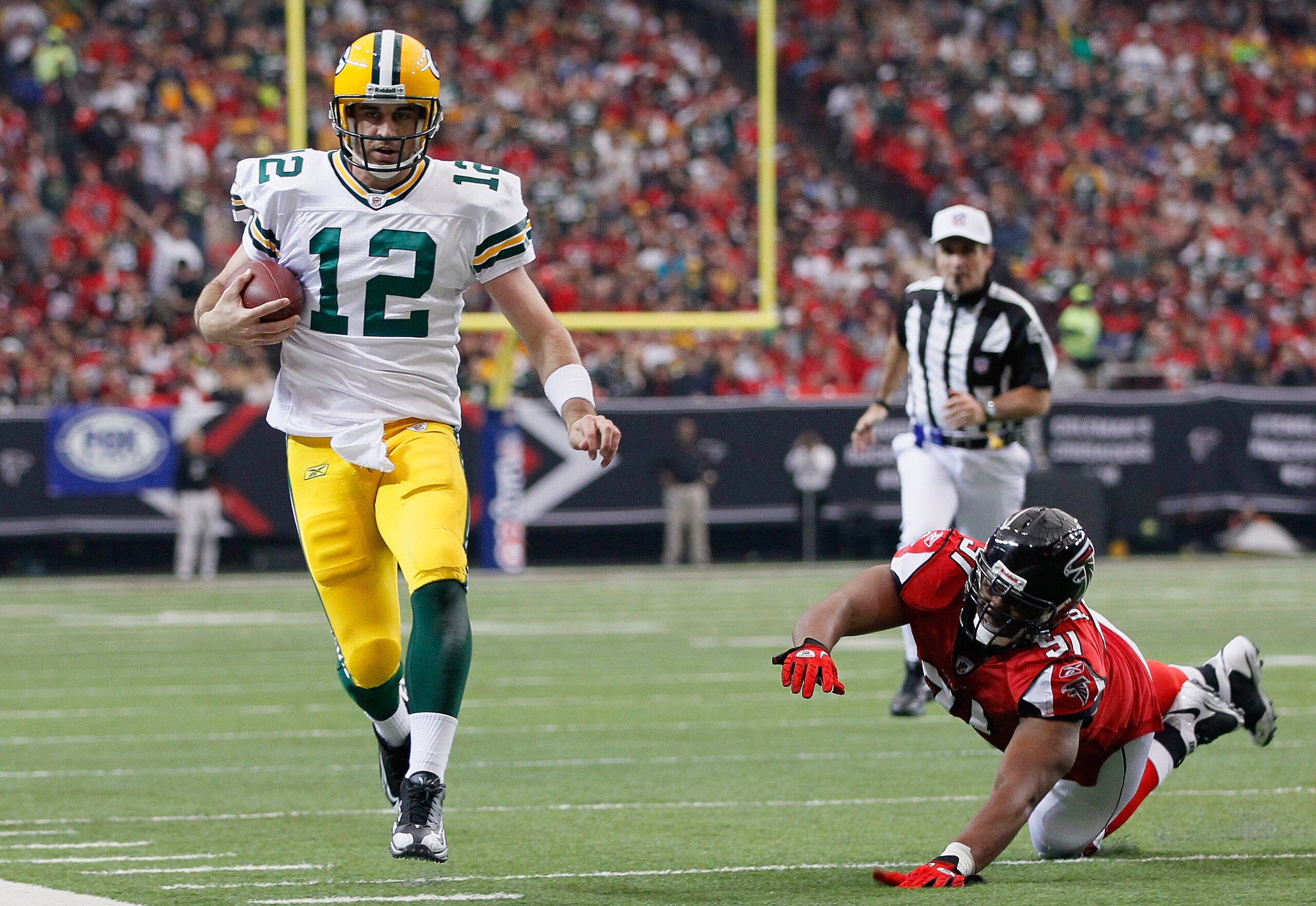 ATLANTA - NOVEMBER 28:  Quarterback Aaron Rodgers #12 of the Green Bay Packers rushes upfield away from Corey Peters #91 of the Atlanta Falcons at Georgia Dome on November 28, 2010 in Atlanta, Georgia.  (Photo by Kevin C. Cox/Getty Images)