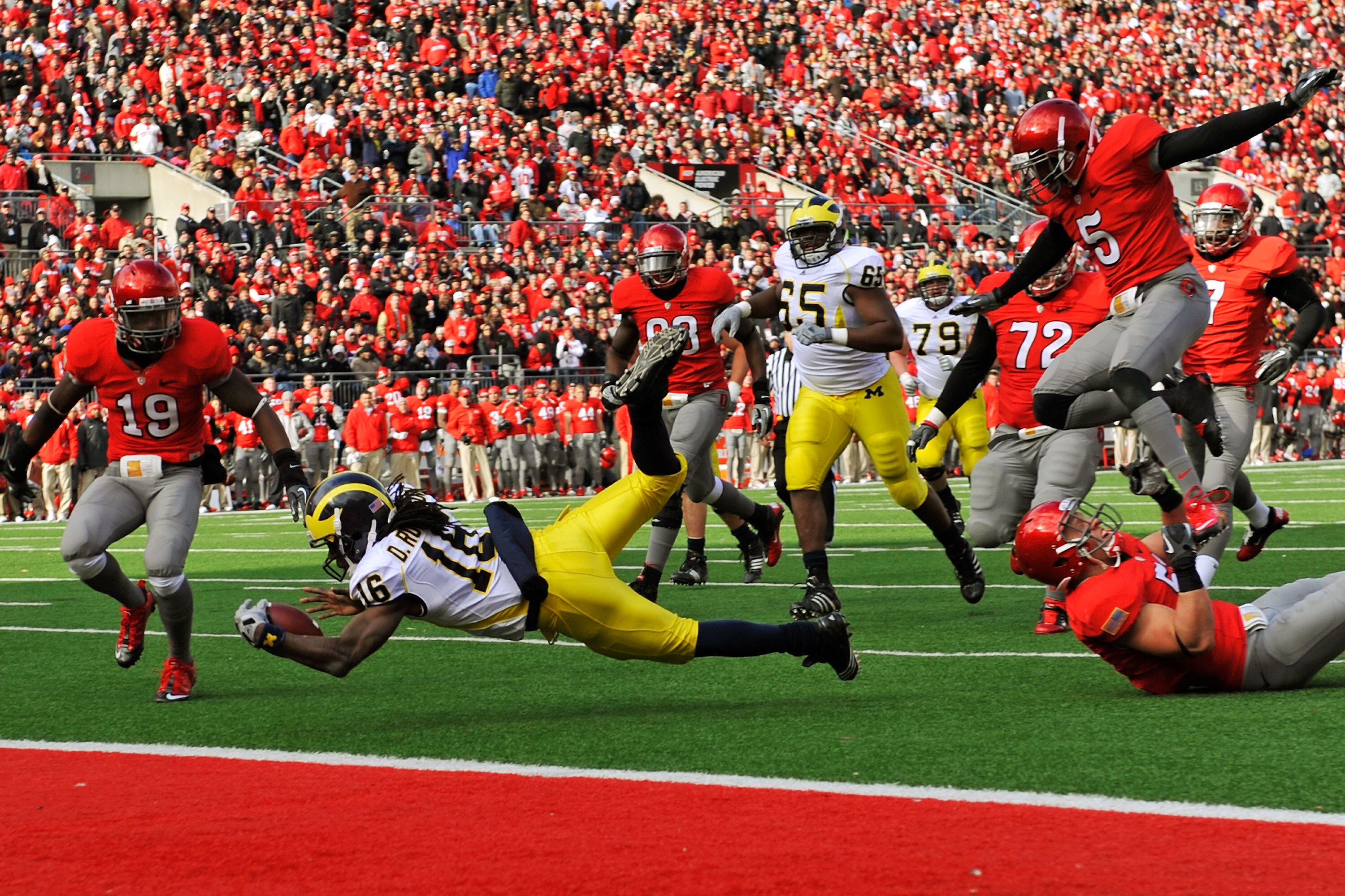 COLUMBUS, OH - NOVEMBER 27:  Quarterback Denard Robinson #16 of the Michigan Wolverines is tripped up just shy of the goal line by Ross Homan #51 of the Ohio State Buckeyes at Ohio Stadium on November 27, 2010 in Columbus, Ohio.  (Photo by Jamie Sabau/Get