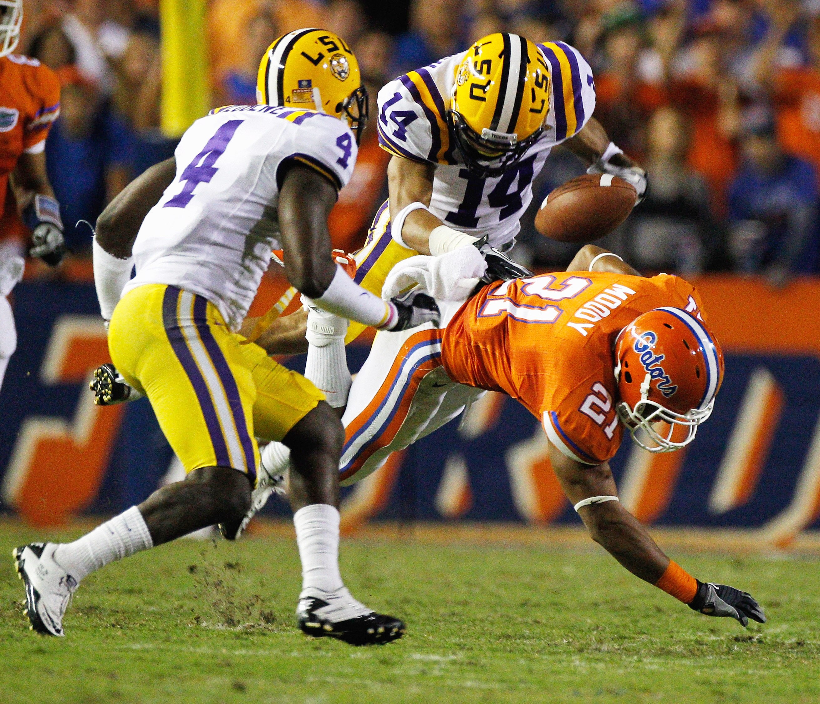GAINESVILLE, FL - OCTOBER 09:  Jai Eugene #4 and Tyrann Mathieu #14 of the Louisiana State University Tigers force Emmanuel Moody #21 of the Florida Gators to fumble during the game at Ben Hill Griffin Stadium on October 9, 2010 in Gainesville, Florida.