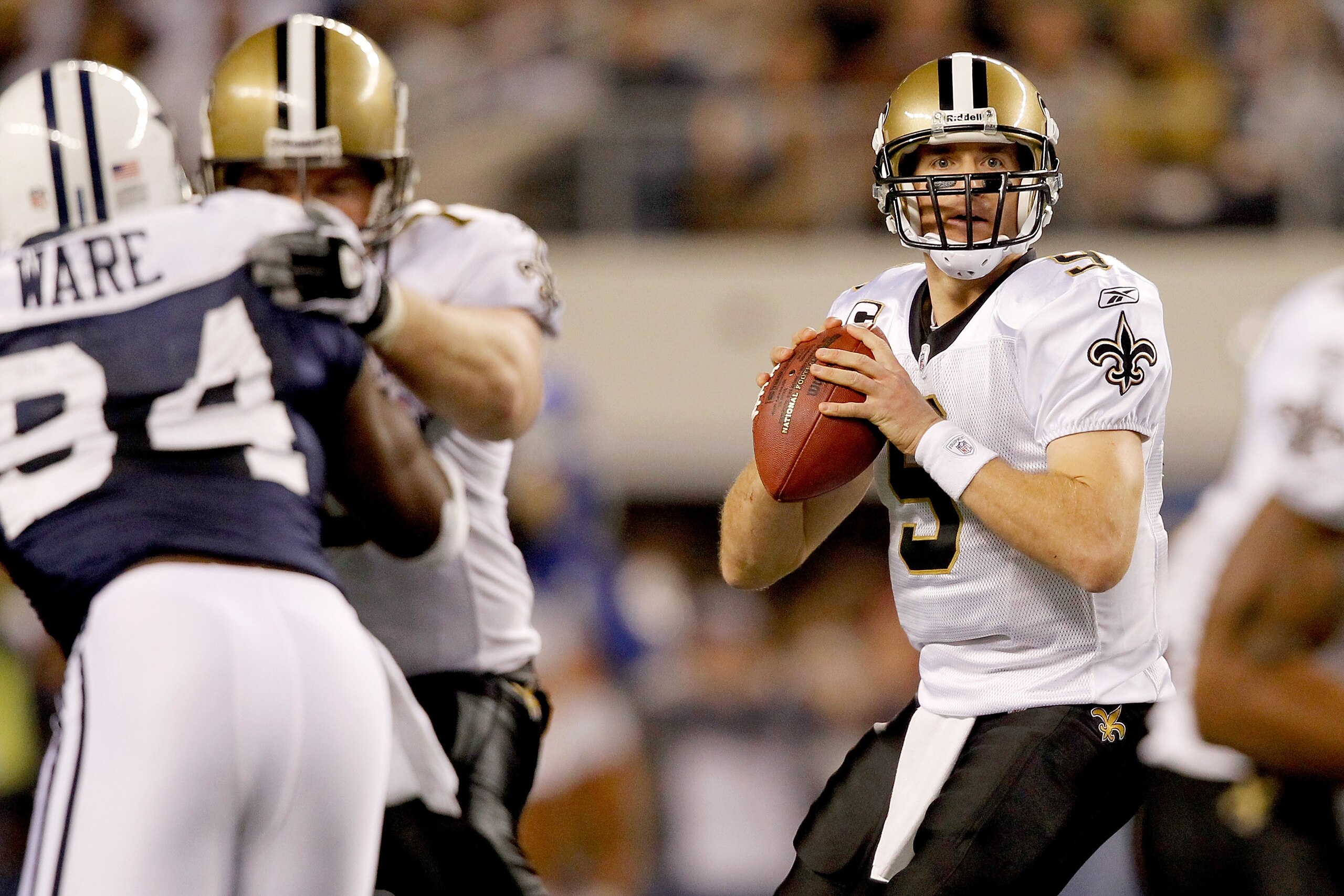 ARLINGTON, TX - NOVEMBER 25:  Quarterback Drew Brees #9 of the New Orleans Saints looks for an open receiver while playing the Dallas Cowboys at Cowboys Stadium on November 25, 2010 in Arlington, Texas.  (Photo by Matthew Stockman/Getty Images)