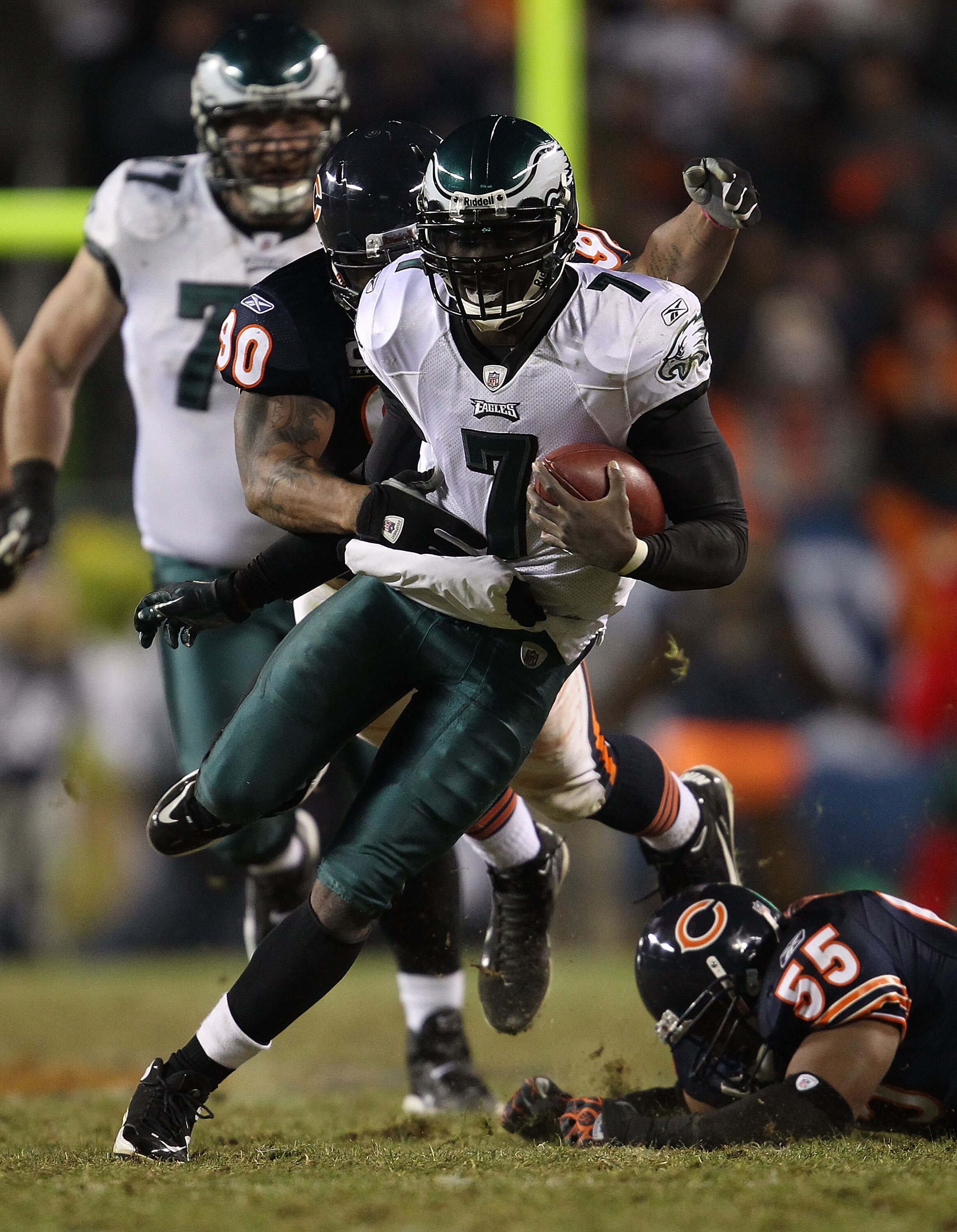 CHICAGO - NOVEMBER 28: Michael Vick #7 of the Philadelphia Eagles is brought down by Julius Peppers #90 of the Chicago Bears after breaking a tackle attempt by Lance Briggs #55 at Soldier Field on November 28, 2010 in Chicago, Illinois. The Bears defeated