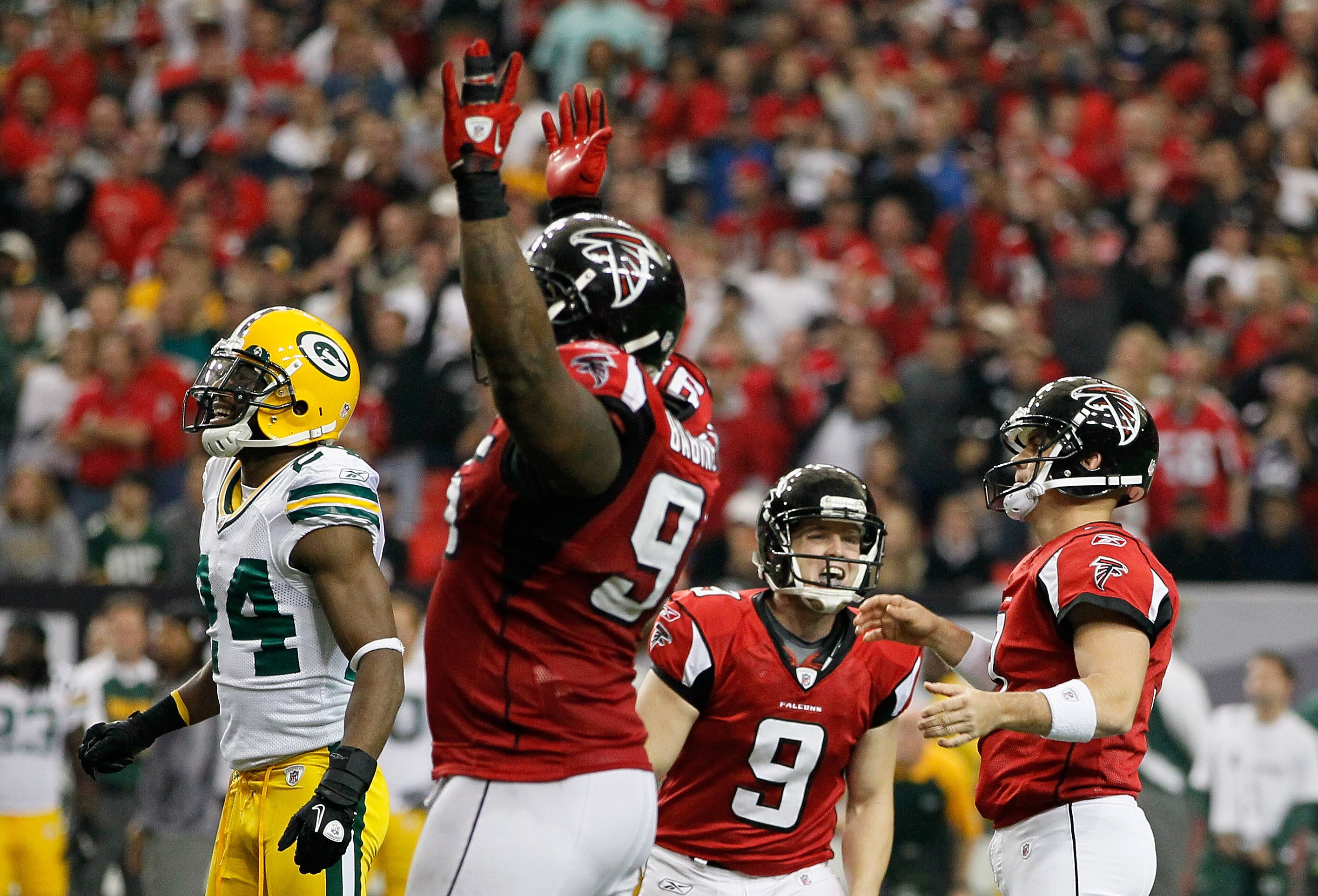 ATLANTA - NOVEMBER 28:  Jarrett Bush #24 of the Green Bay Packers looks on as Michael Koenen, Jonathan Babineaux #95 and Matt Bryant #3 of the Atlanta Falcons celebrate Bryant's go-ahead field goal in the final seconds at Georgia Dome on November 28, 2010