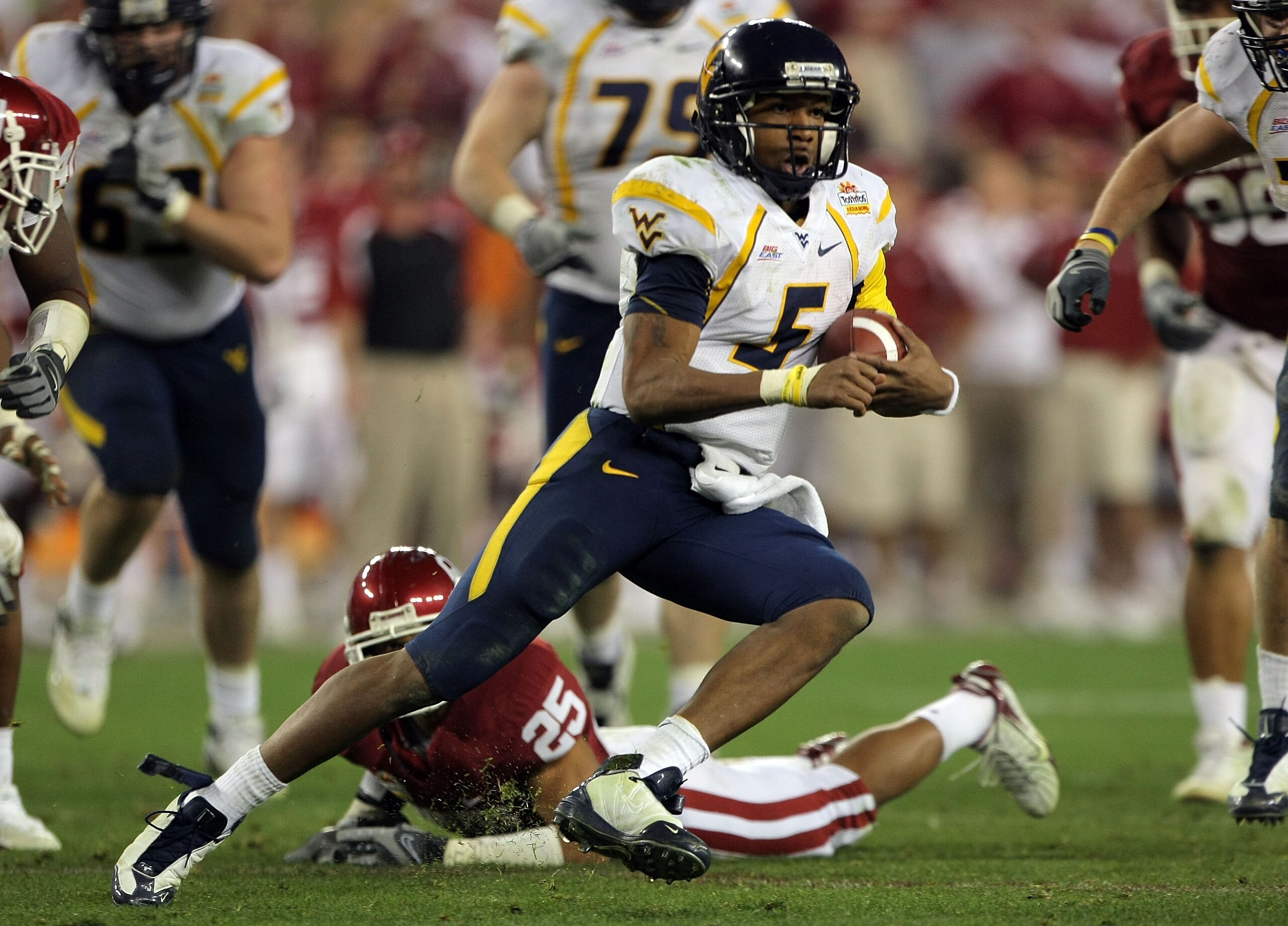 GLENDALE, AZ - JANUARY 02: Quarterback Patrick White #5 of the West Virginia Mountaineers runs for seven-yards past D.J. Wolfe #25 of the Oklahoma Sooners in the second half at the Tostito's Fiesta Bowl at University of Phoenix Stadium January 2, 2008 in GLENDALE, AZ - JANUARY 02: Quarterback Patrick White #5 of the West Virginia Mountaineers runs for seven-yards past D.J. Wolfe #25 of the Oklahoma Sooners in the second half at the Tostito's Fiesta Bowl at University of Phoenix Stadium January 2, 2008 in