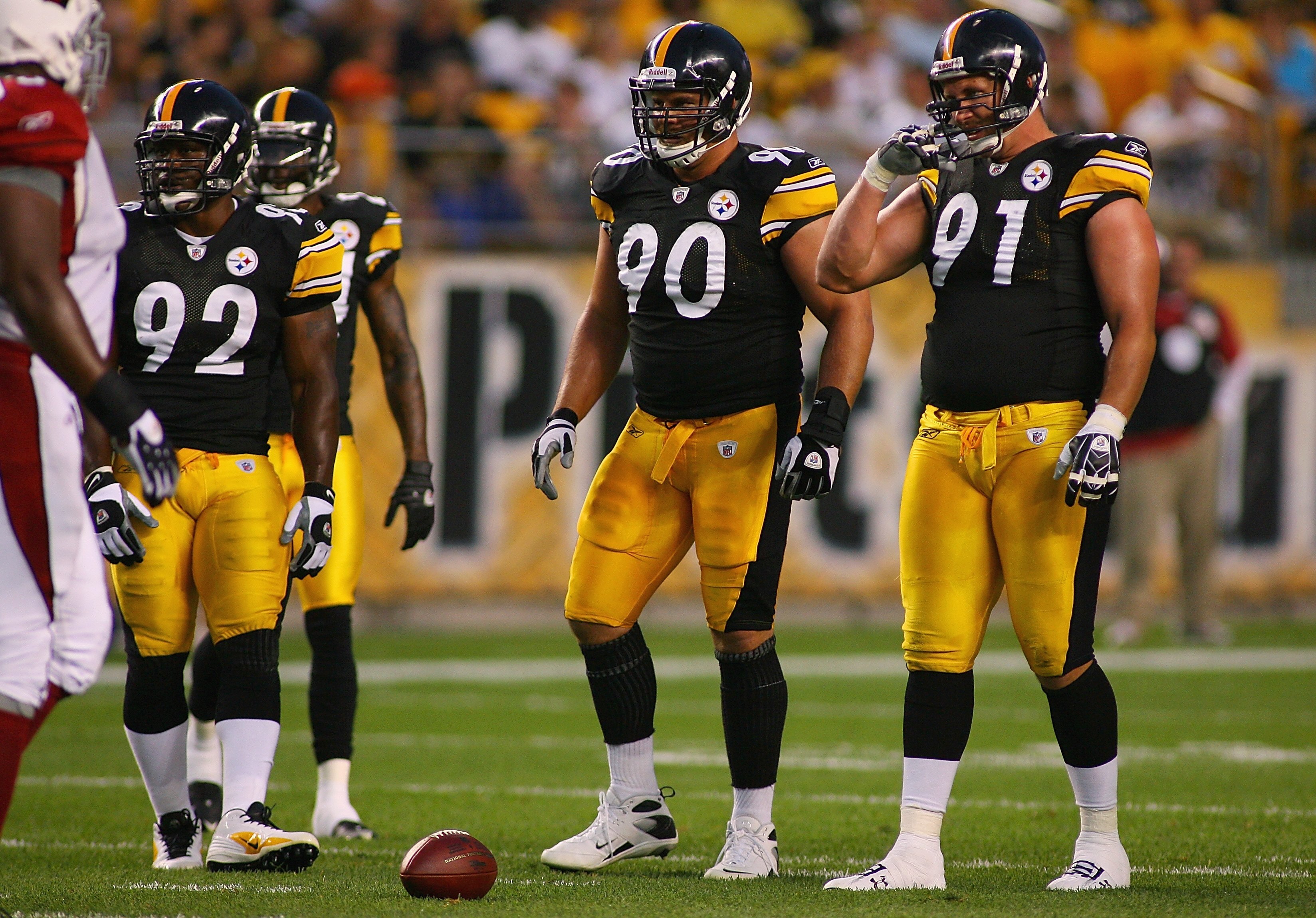 PITTSBURGH - AUGUST 13:  (L-R) James Harrison #92, Travis Kirschke #90, and Aaron Smith #91 of the Pittsburgh Steelers stand at the line of scrimmage during the preseason NFL game against the Arizona Cardinals at Heinz Field on August 13, 2009 in Pittsbur