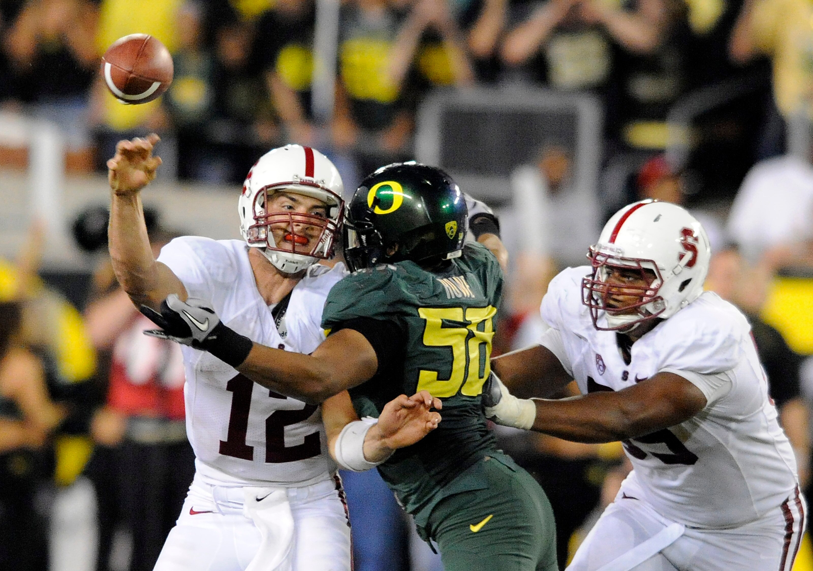 EUGENE, OR - OCTOBER 2: Quarterback Andrew Luck of the Stanford Cardinal is hit  by defensive end Kenny Rowe #58 of the Oregon Ducks in the third quarter of the game at Autzen Stadium on October 2, 2010 in Eugene, Oregon. Oregon won the game 52-31. (Photo