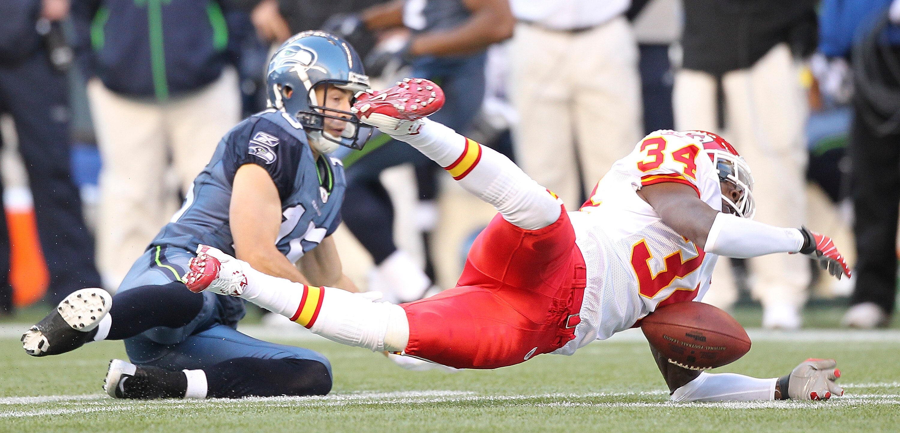 SEATTLE - NOVEMBER 28:  Cornerback Travis Daniels #34 of the Kansas City Chiefs can't hang onto the ball on an interception attempt against Brandon Stokley #15 of the Seattle Seahawks at Qwest Field on November 28, 2010 in Seattle, Washington. The Chiefs