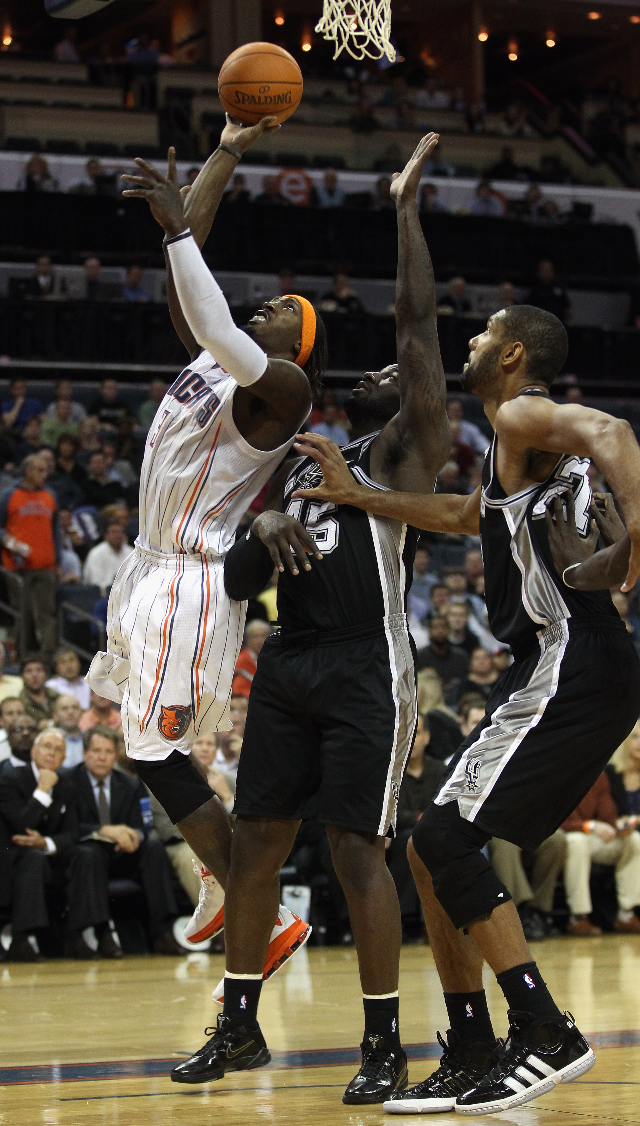 CHARLOTTE, NC - NOVEMBER 08:  Teammates DeJuan Blair #45 and Tim Duncan #21 of the San Antonio Spurs try to stop Gerald Wallace #3 of the Charlotte Bobcats during their game at Time Warner Cable Arena on November 8, 2010 in Charlotte, North Carolina.  NOT