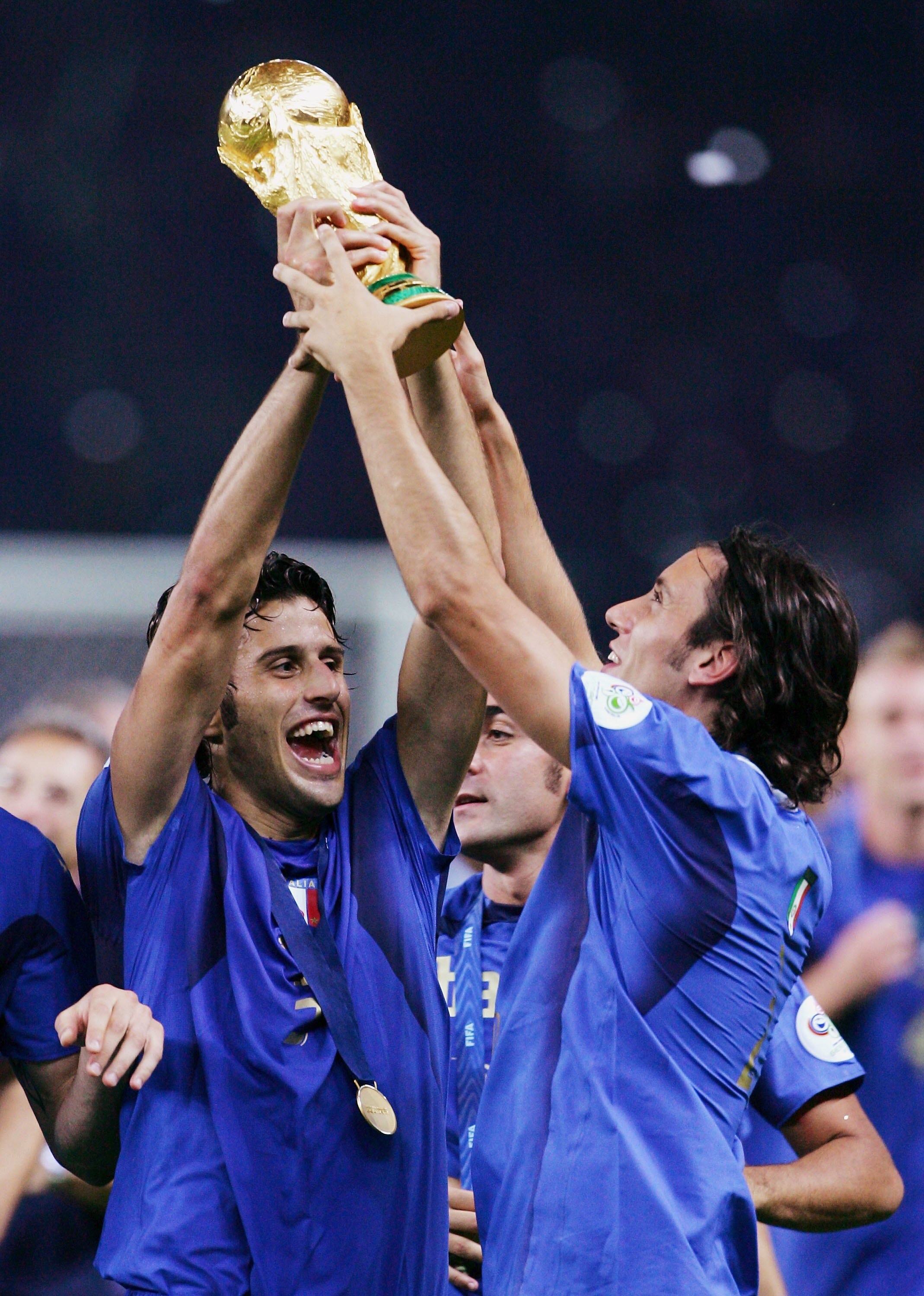 BERLIN - JULY 09:  Fabio Grosso (L) of Italy holds the World Cup trophy aloft following his team's victory in a penalty shootout at the end of the FIFA World Cup Germany 2006 Final match between Italy and France at the Olympic Stadium on July 9, 2006 in B