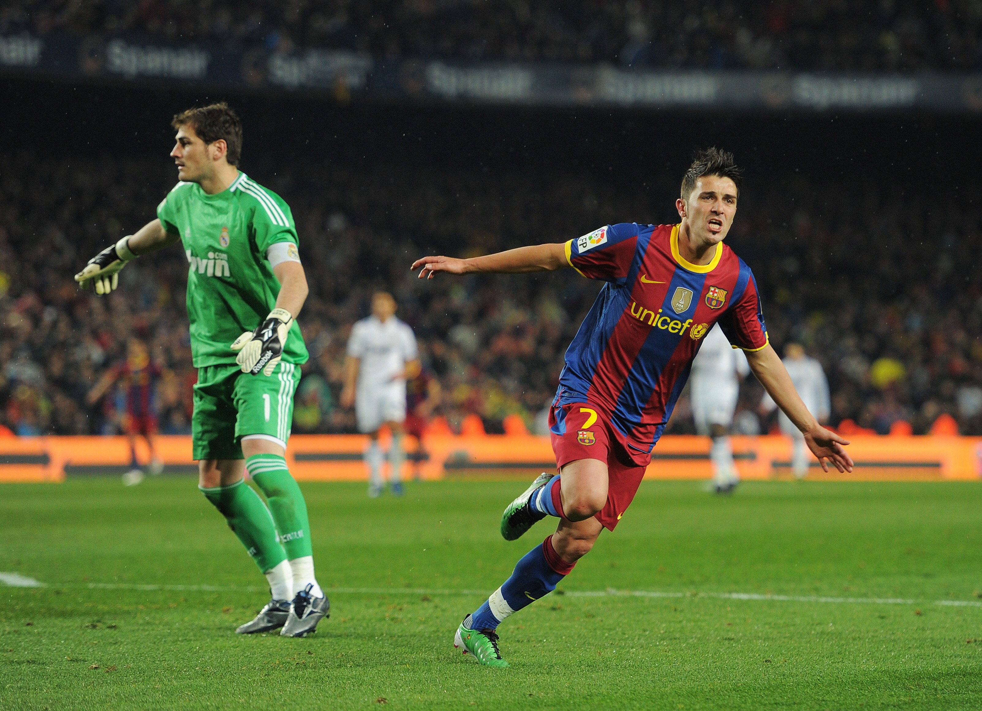 BARCELONA, SPAIN - NOVEMBER 29:  David Villa (R) of Barcelona runs past goalkeeper Iker Casillas of Real Madrid as he celebrates scoring his sides fourth goal during the la liga match between Barcelona and Real Madrid at the Camp Nou stadium on November 2