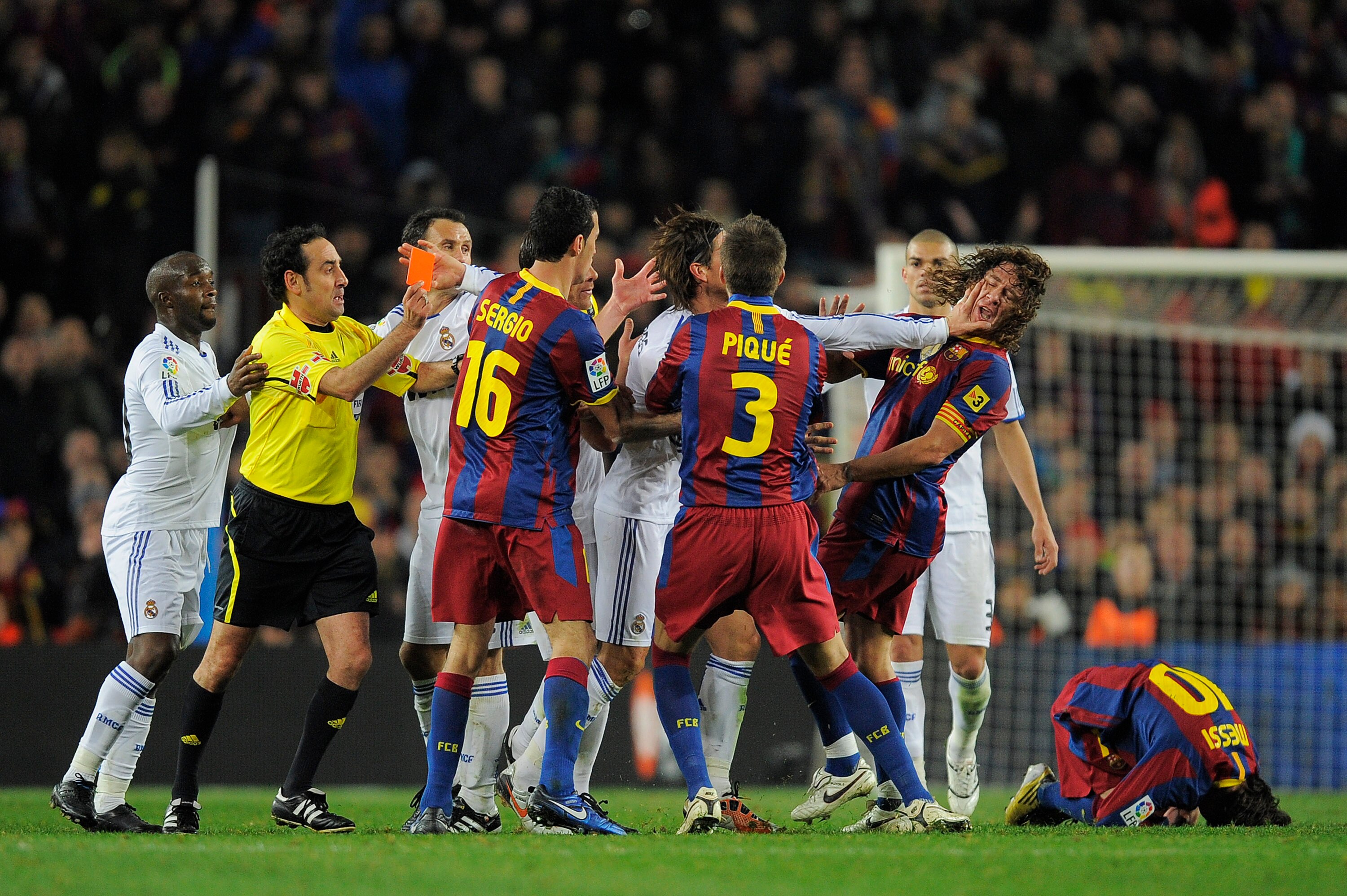 BARCELONA, SPAIN - NOVEMBER 29:  Sergio Ramos of Reral Madrid pushes Carles Puyol's face  (2ndR) during the La Liga match between Barcelona and Real Madrid at the Camp Nou Stadium on November 29, 2010 in Barcelona, Spain.  Barcelona won the match 5-0.  (P