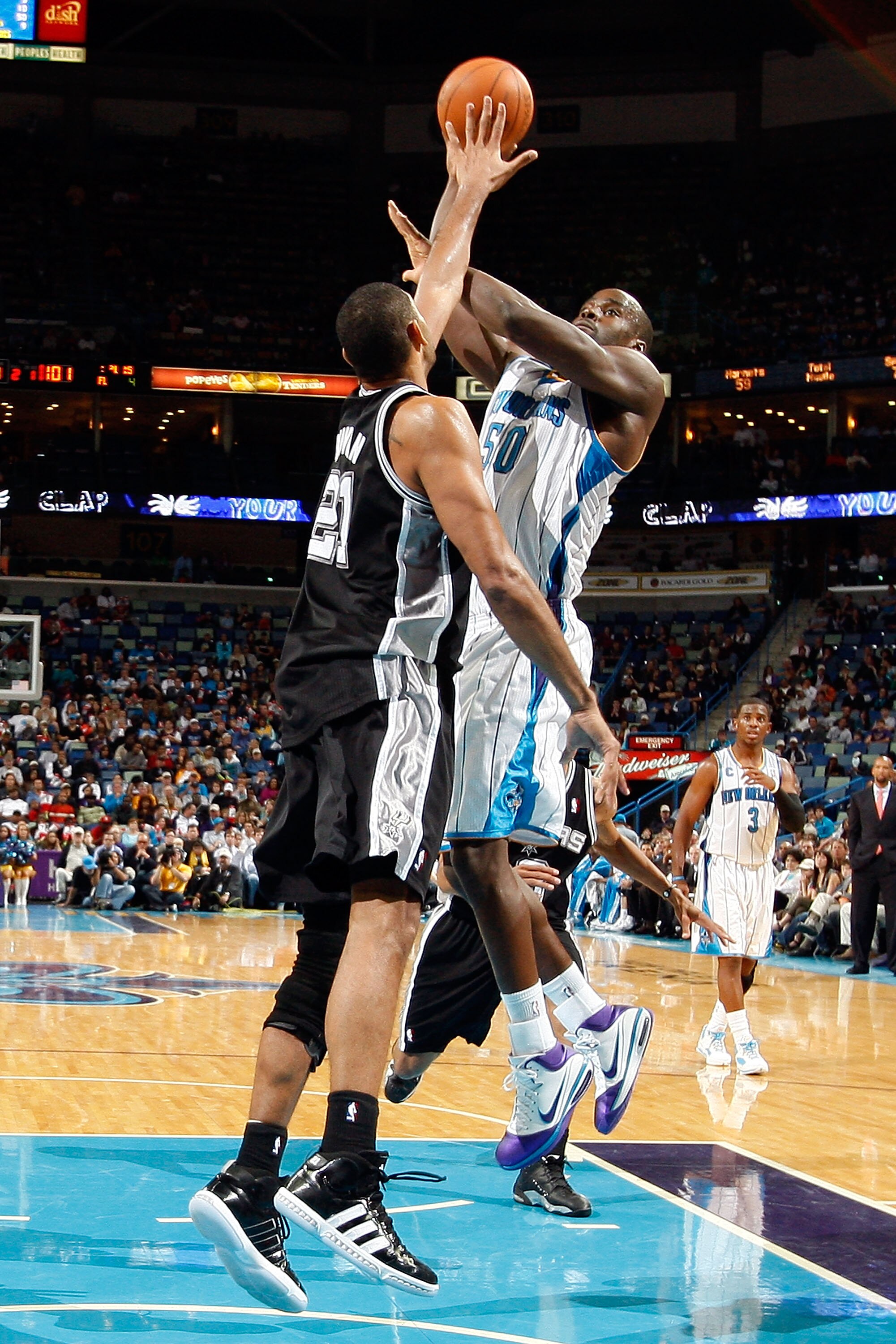 NEW ORLEANS - NOVEMBER 28:  Emeka Okafor #50 of the New Orleans Hornets shoots the ball over Tim Duncan #21 of the San Antonio Spurs at the New Orleans Arena on November 28, 2010 in New Orleans, Louisiana.  NOTE TO USER: User expressly acknowledges and ag