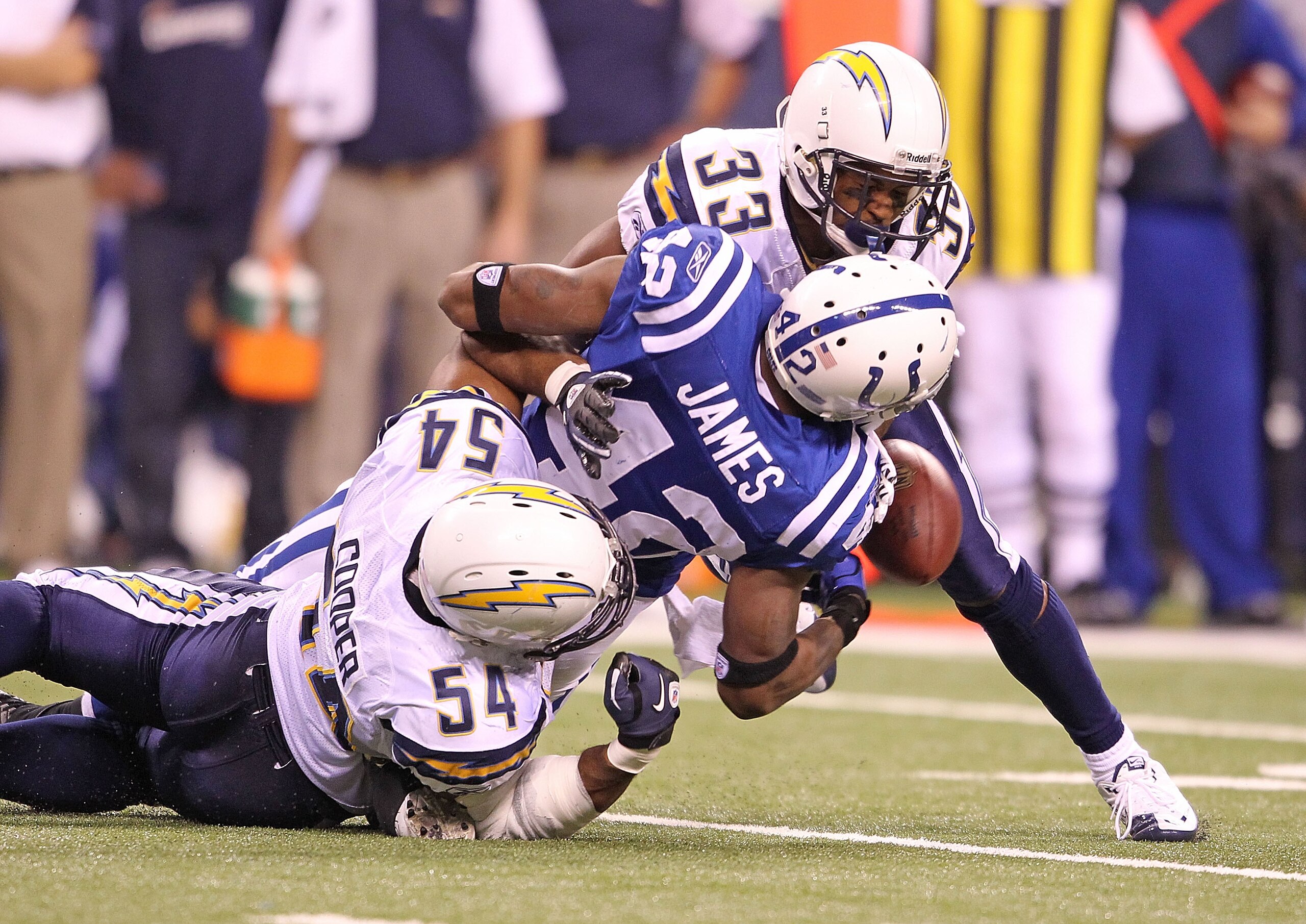 INDIANAPOLIS - NOVEMBER 28:  Javarris James #42 of the Indianapolis Colts fumbles the ball while being  tackled by Stephen Cooper #54 and Dante Hughes #33 of the San Diego Chargers during the NFL game at Lucas Oil Stadium on November 28, 2010 in Indianapo