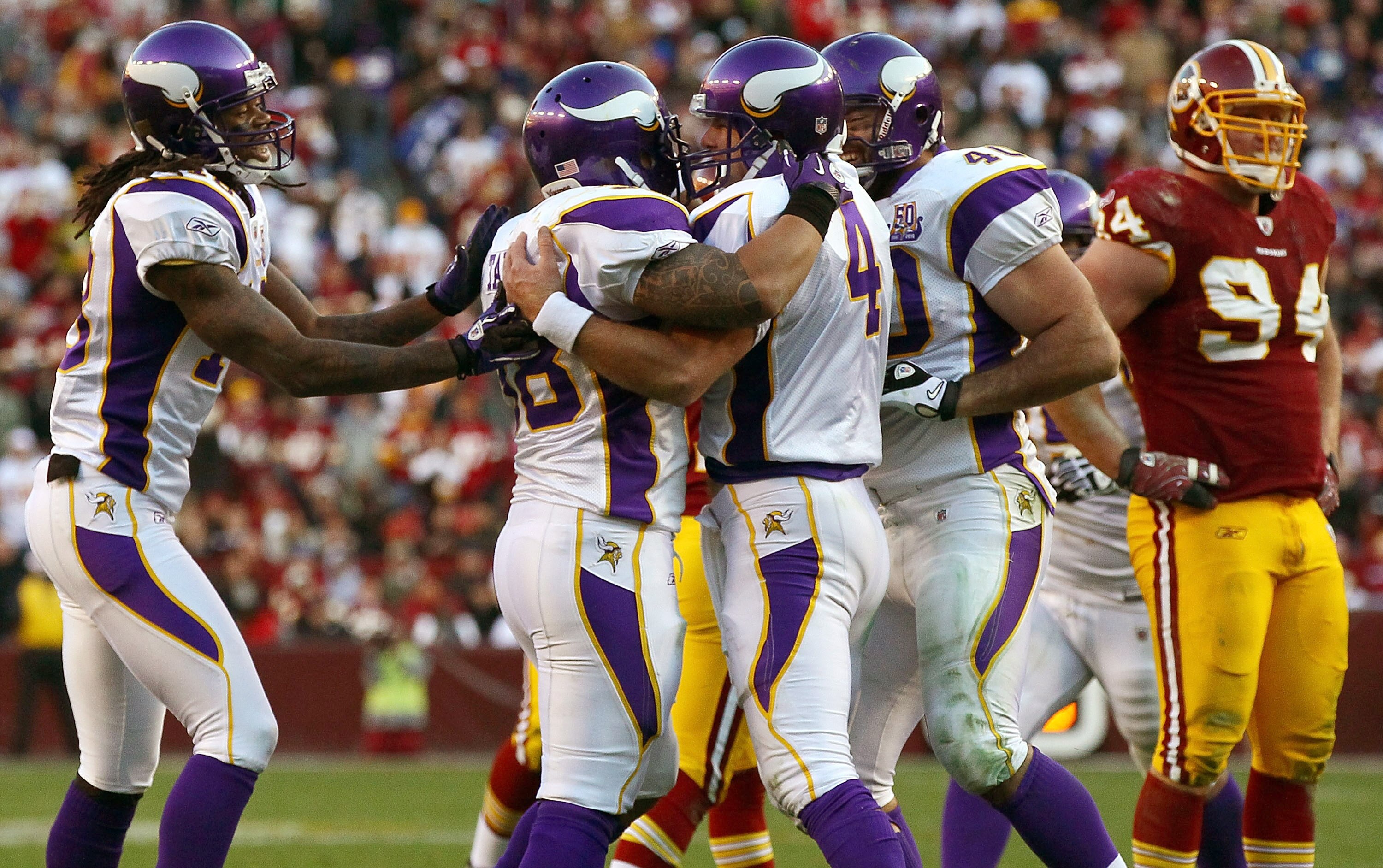 LANDOVER, MD - NOVEMBER 28:  Brett Favre #4 of the Minnesota Vikings is congratulated by teammates after running for a key first down in the fourth quarter FedExField November 28, 2010 in Landover, Maryland. The Vikings won the game 17-13.  (Photo by Win