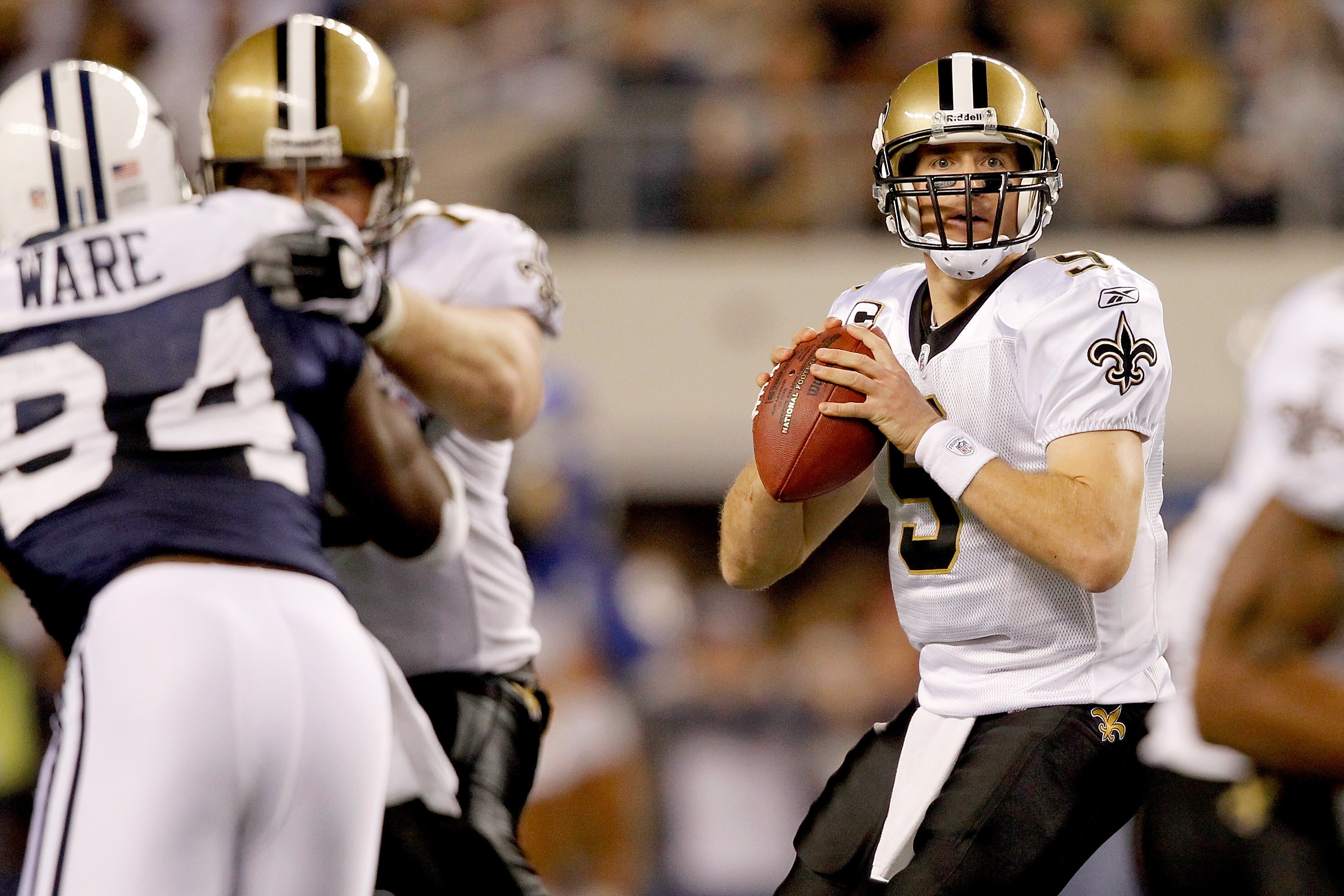 ARLINGTON, TX - NOVEMBER 25:  Quarterback Drew Brees #9 of the New Orleans Saints looks for an open receiver while playing the Dallas Cowboys at Cowboys Stadium on November 25, 2010 in Arlington, Texas.  (Photo by Matthew Stockman/Getty Images)