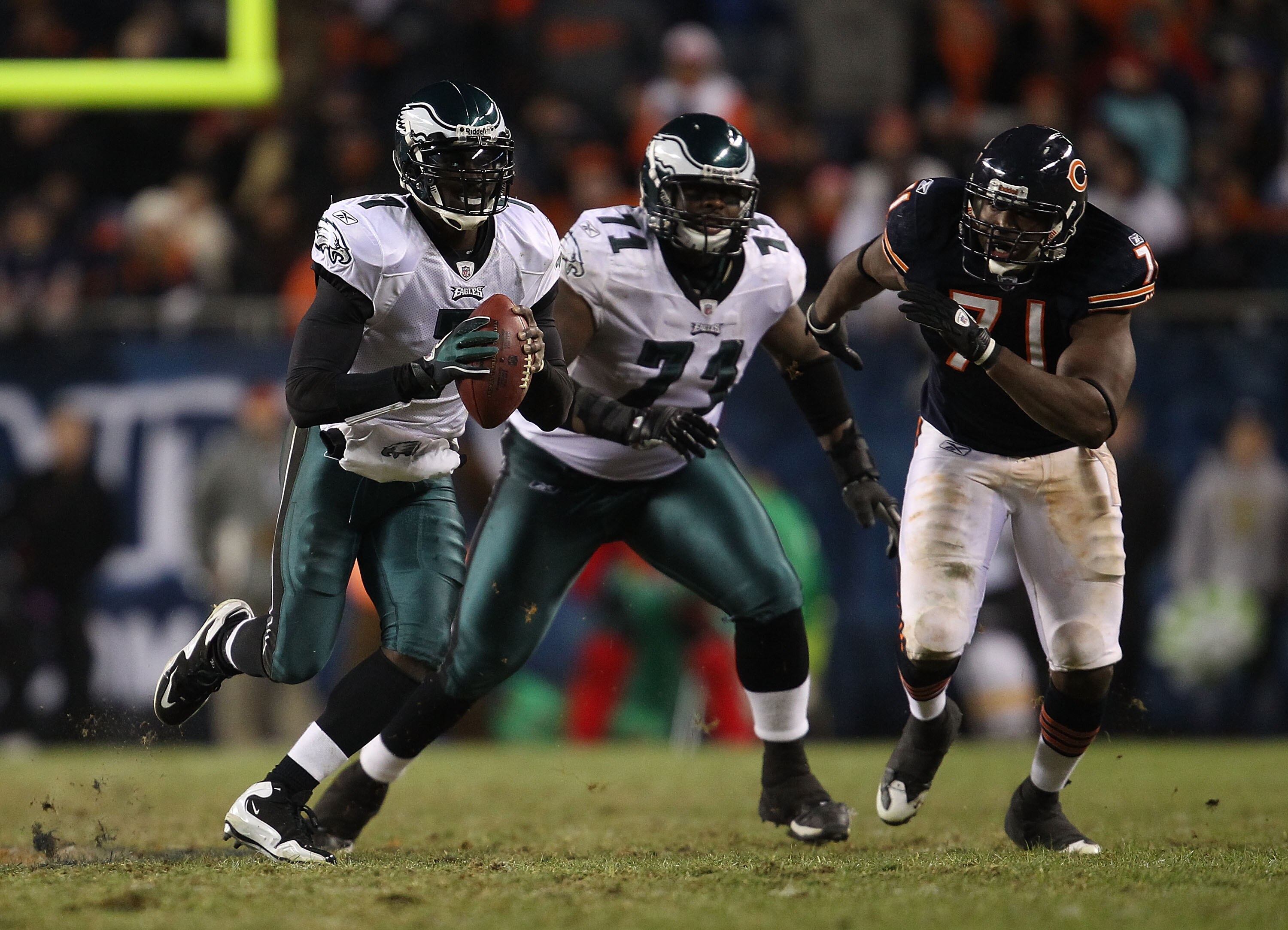 CHICAGO - NOVEMBER 28: Michael Vick #7 of the Philadelphia Eagles looks for a receiver as teammate Jason Peters #71 and Israel Idonije #71 of the Chicago Bears trail the play at Soldier Field on November 28, 2010 in Chicago, Illinois. The Bears defeated t