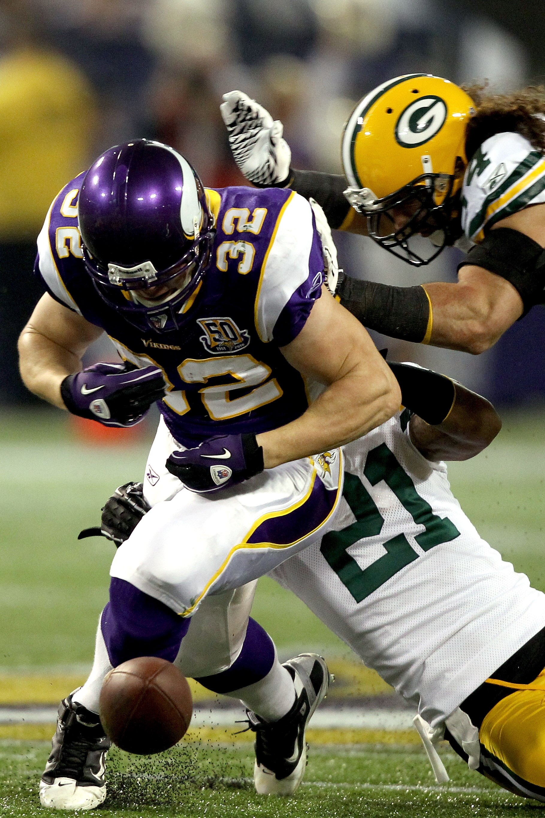 MINNEAPOLIS - NOVEMBER 21:  Toby Gerhart #32 of the Minnesota Vikings has the ball jarred loose by Charles Woodson #21 and Brandon Chillar #54 of the Green Bay Packers at the Hubert H. Humphrey Metrodome on November 21, 2010 in Minneapolis, Minnesota.  (P
