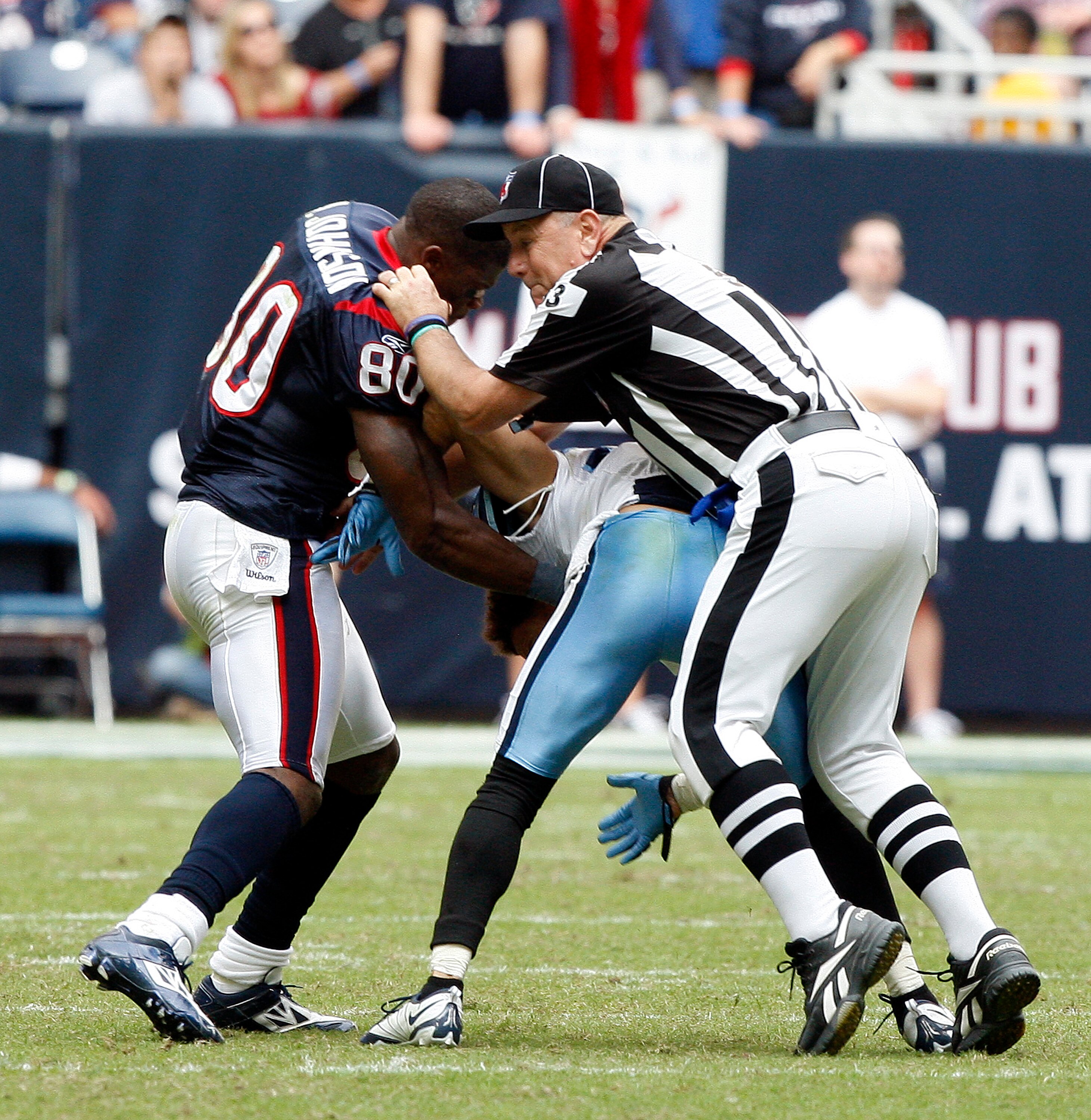HOUSTON - NOVEMBER 28:  Wide receiver Andre Johnson #80 of the Houston Texans is separated by umpire Garth DeFerlice #53 from cornerback Cortland Finnegan #31 of the Tennessee Titans after the two exchanged punches in the fourth quarter at Reliant Stadium