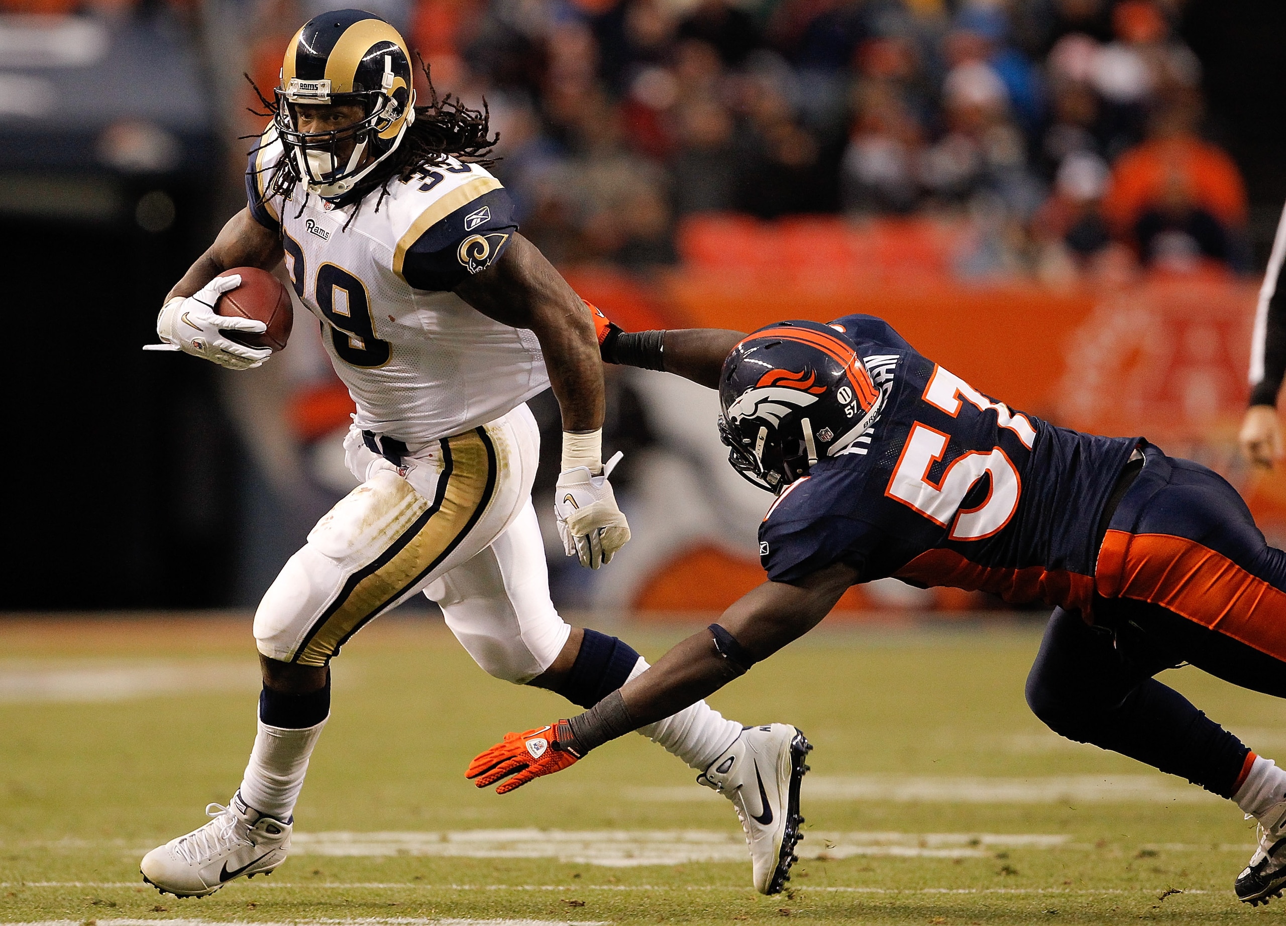 DENVER - NOVEMBER 28:  Running back Steven Jackson #39 of the St. Louis Rams escapes a diving effort by linebacker Mario Haggan #57 of the Denver Broncos on his way to a 20-yard gain during the third quarter at INVESCO Field at Mile High on November 28, 2