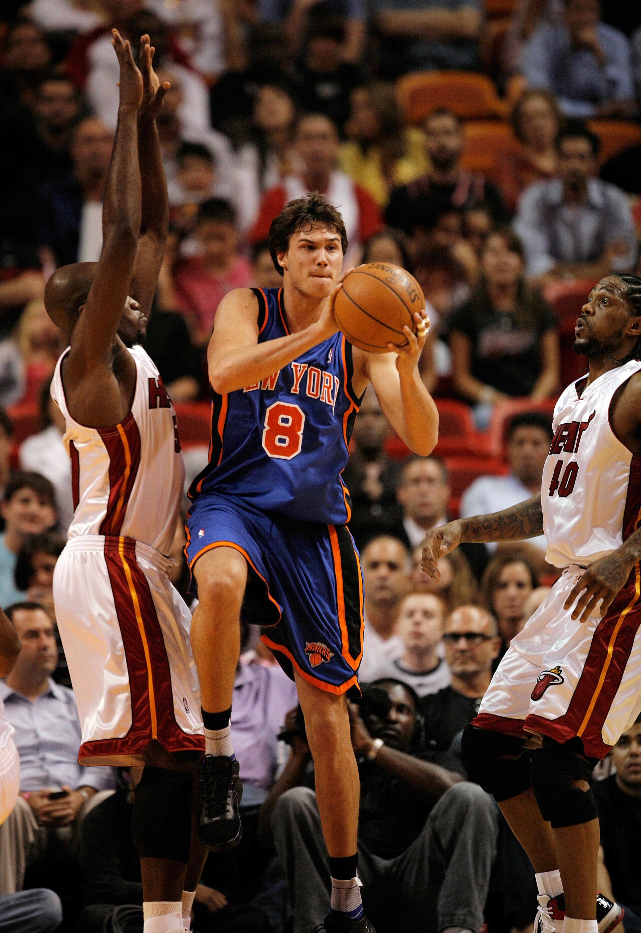 MIAMI - OCTOBER 28:  Danilo Gallinari #8 of the New York Knicks passes away from the pressure of Joel Anthony #50 and Udonis Haslem #40 of the Miami Heat at AmericanAirlines Arena on October 28, 2009 in Miami, Florida. The Heat defeated the Knicks 115-93.