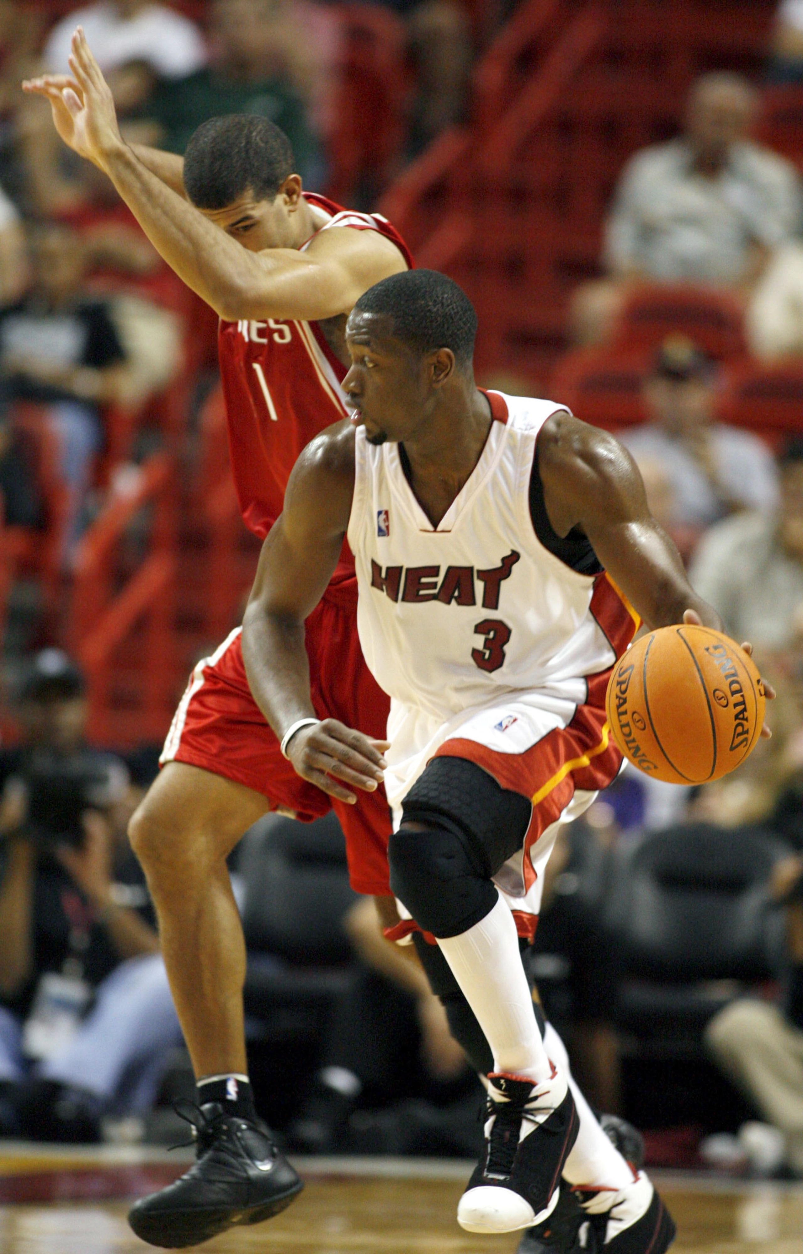 MIAMI - OCTOBER 25:  Guard Dwyane Wade #3 of the Miami Heat drives away from Shane Battier #31of the Houston Rockets during their preseason game on October 25, 2006 at the American Airlines Arena in Miami  Florida.  NOTE TO USER: User expressly acknowledg