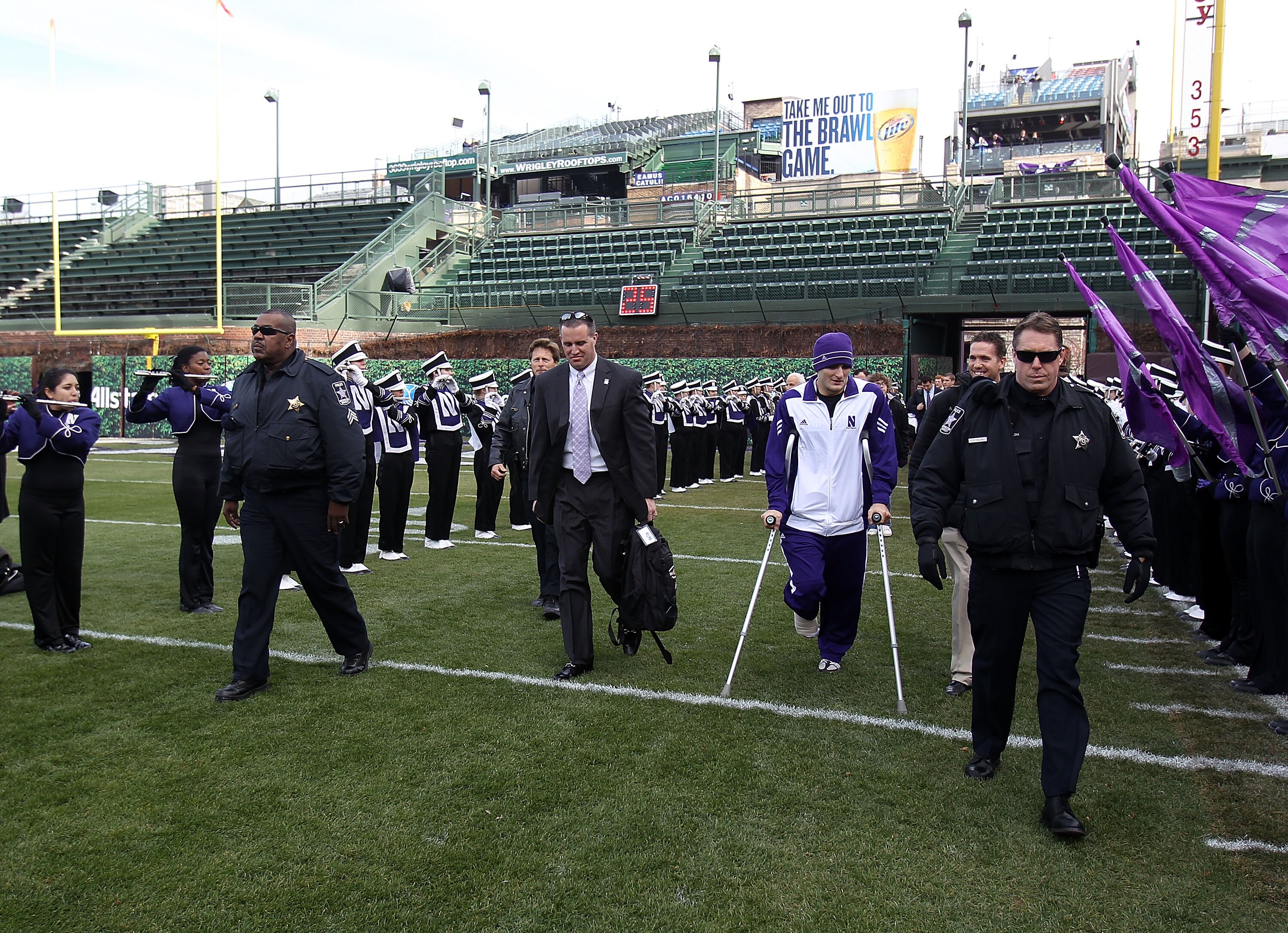 CHICAGO - NOVEMBER 20: Head coach Pat Fitzgerald of the Northwestern Wildcats (center) and injured quarterback Dan Persa enter the field before a game against the Illinois Fighting Illini to be played at Wrigley Field on November 20, 2010 in Chicago, Illi