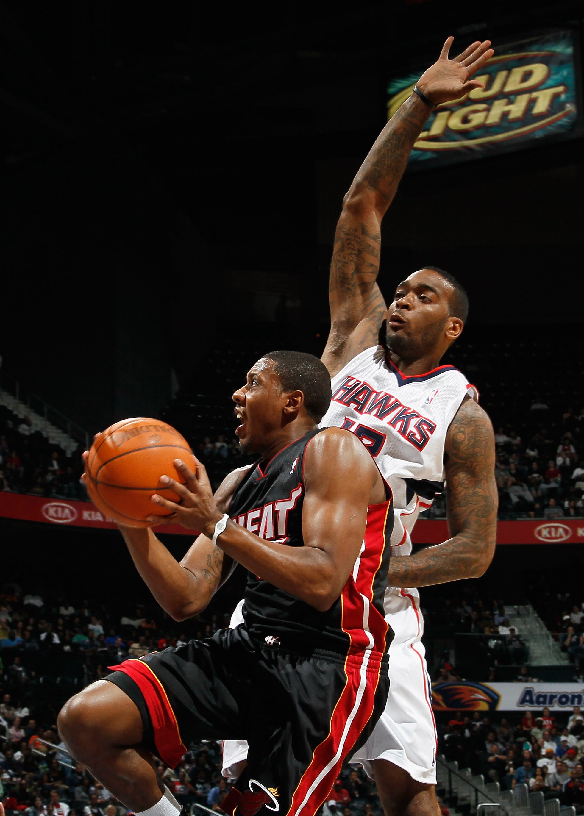 ATLANTA - OCTOBER 21:  Mario Chalmers #15 of the Miami Heat drives the basket against Josh Powell #12 of the Atlanta Hawks at Philips Arena on October 21, 2010 in Atlanta, Georgia.  (Photo by Kevin C. Cox/Getty Images)