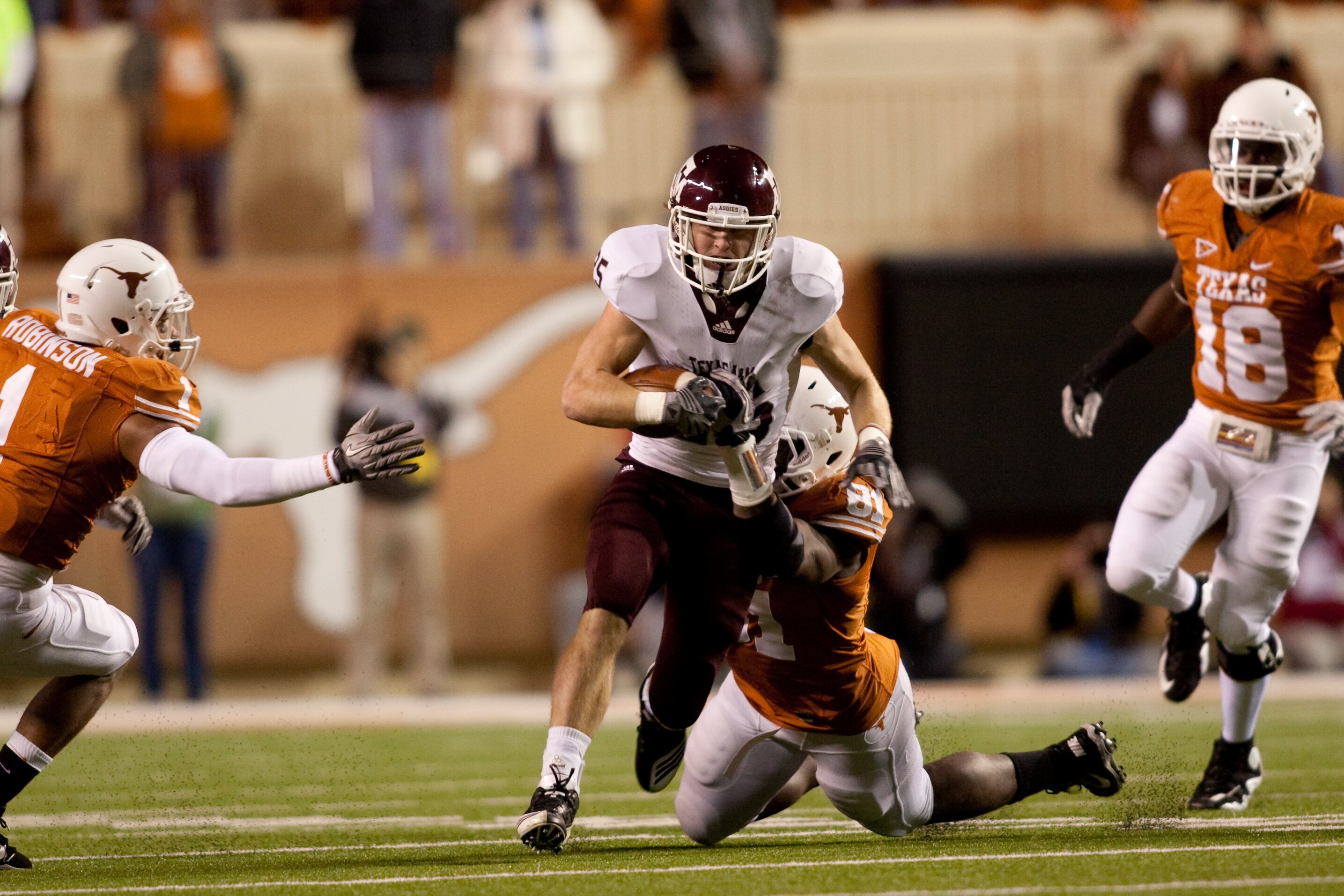 AUSTIN, TX - NOVEMBER 25:  Running back Ryan Swope of Texas A&M #25 tries to break a tackle by University of Texas defensive end Sam Acho #81 during the first half at Darrell K. Royal-Texas Memorial Stadium on November 25, 2010 in Austin, Texas. (Photo by