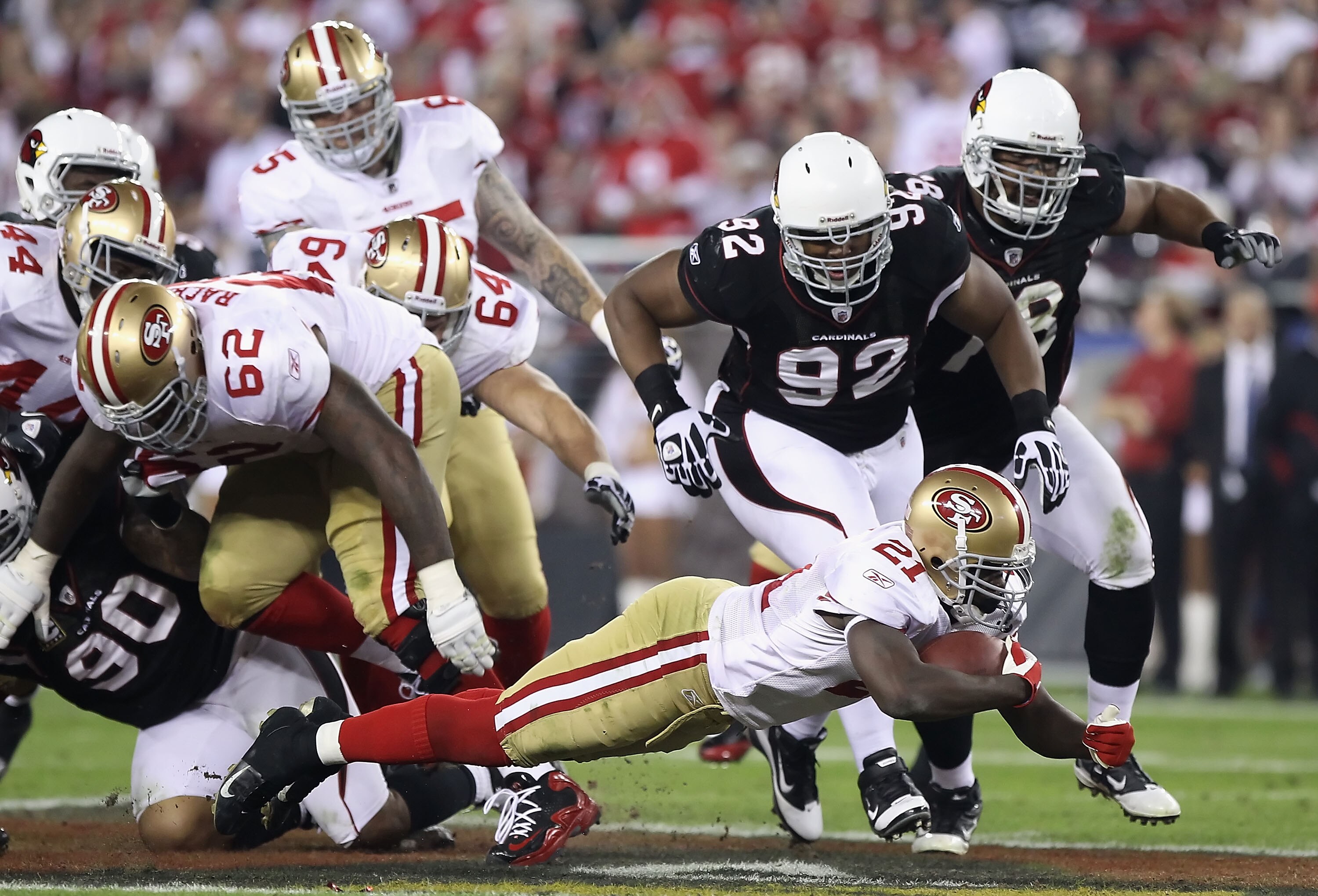 GLENDALE, AZ - NOVEMBER 29:  Runningback Frank Gore #21 of the San Francisco 49ers dives for extra yards past Dan Williams #92 of the Arizona Cardinals during the first quarter of the NFL game at the University of Phoenix Stadium on November 29, 2010 in G