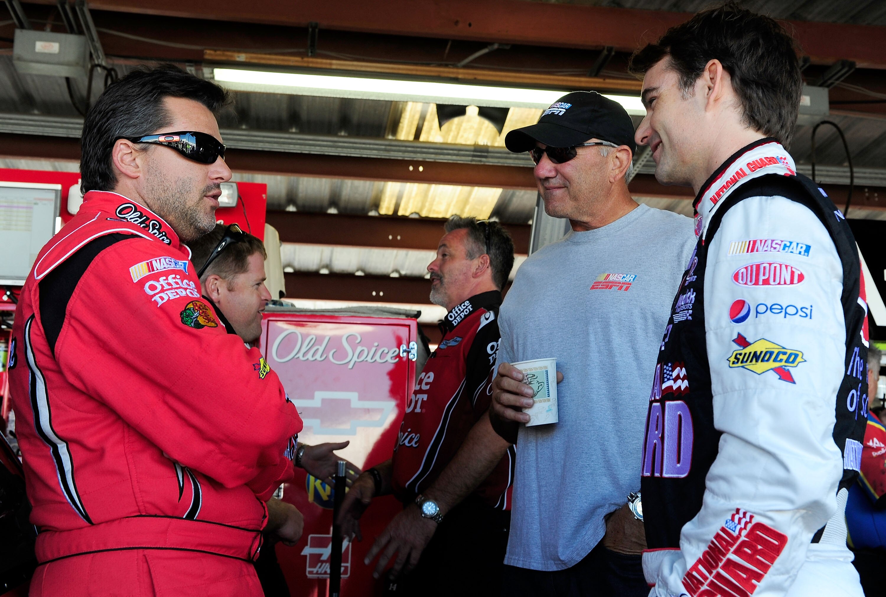 RICHMOND, VA - SEPTEMBER 10:  Tony Stewart (L), driver of the #14 Office Depot/Old Spice Chevrolet, talks with television personality Dale Jarrett (C) and Jeff Gordon (R), driver of the #24 DuPont/National Guard Chevrolet, in the garage during practice fo