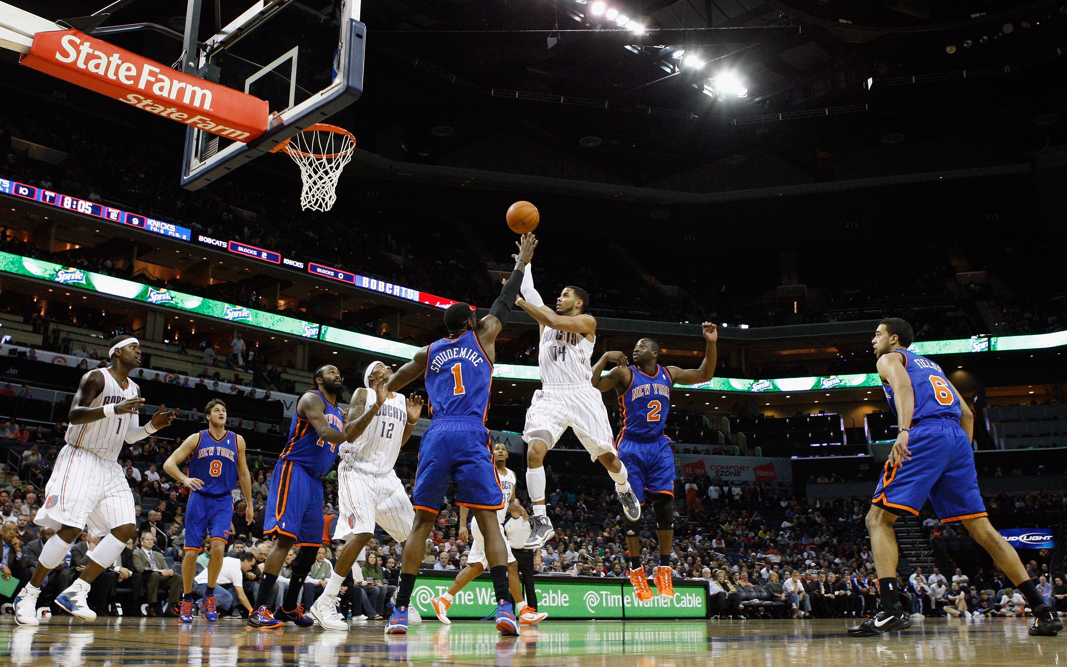 CHARLOTTE, NC - NOVEMBER 24:  Amare Stoudemire #1 of the New York Knicks watches as D.J. Augustin #14 of the Charlotte Bobcats puts up a shot in the lane during their game at Time Warner Cable Arena on November 24, 2010 in Charlotte, North Carolina.  NOTE