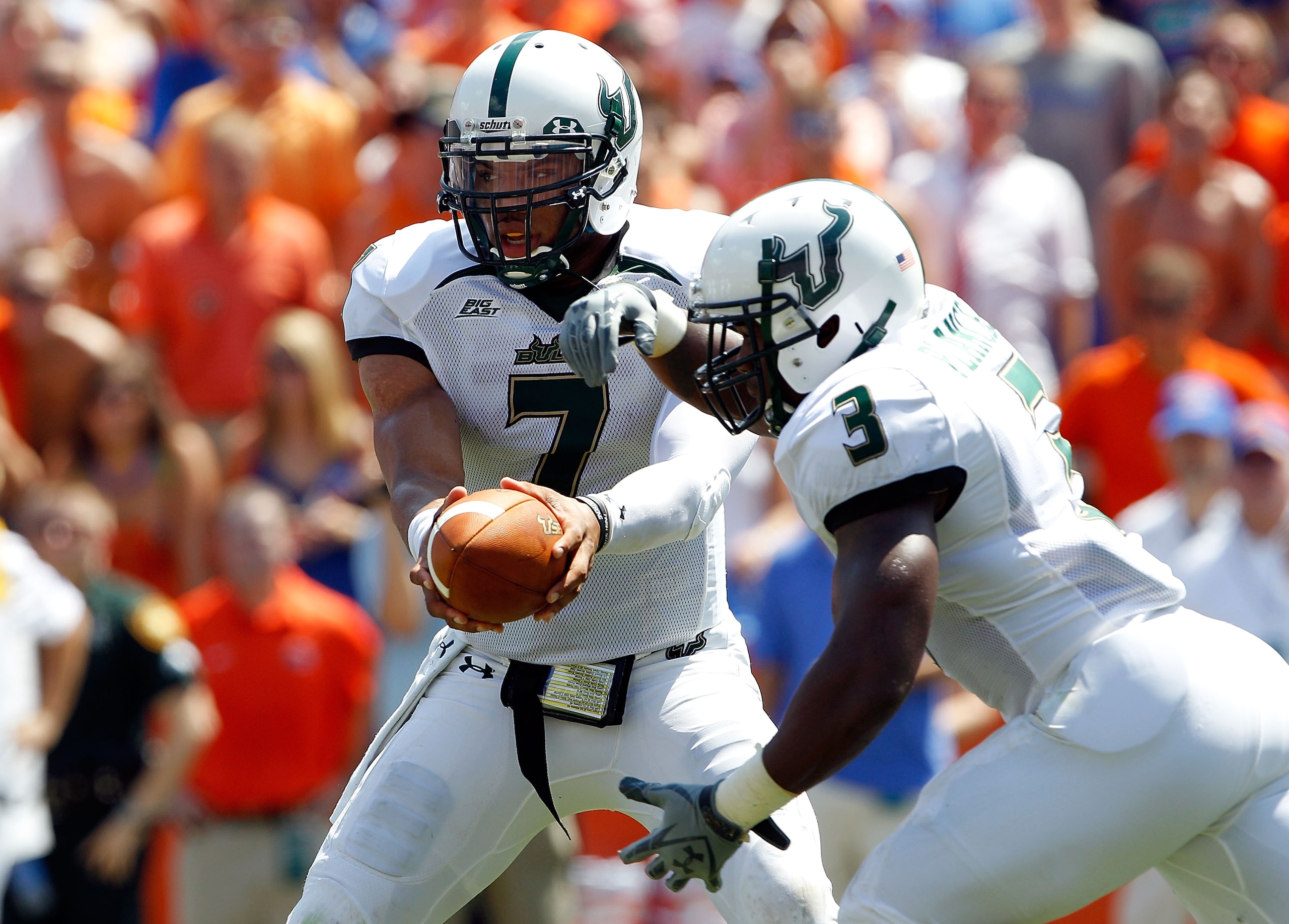 GAINESVILLE, FL - SEPTEMBER 11:  Quarterback B.J. Daniels #7 gives the ball to  Moise Plancher #3 of the South Florida Bulls during a game against the Florida Gators at Ben Hill Griffin Stadium on September 11, 2010 in Gainesville, Florida.  (Photo by Sam
