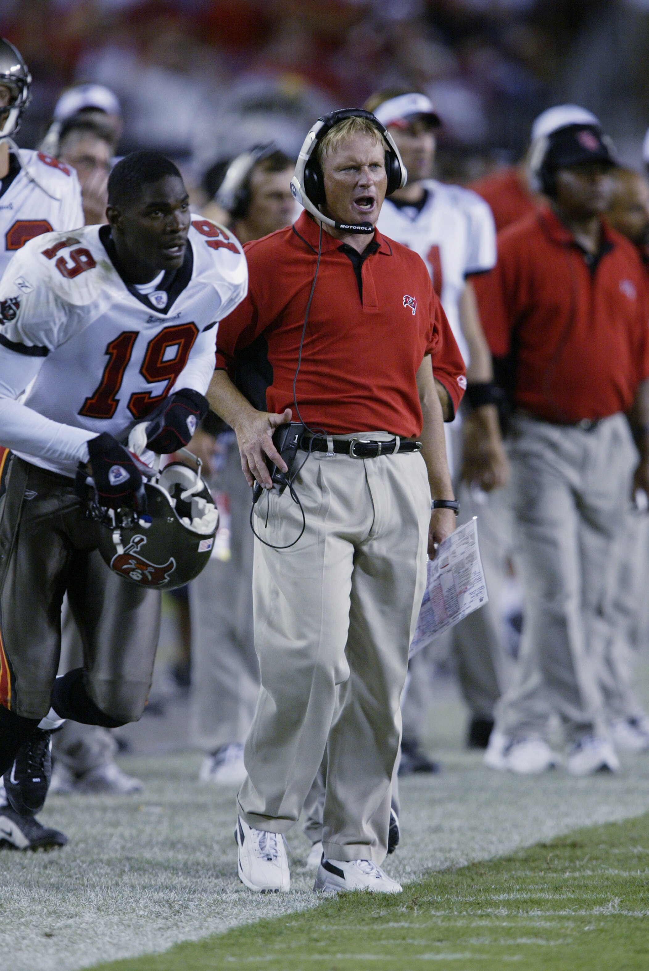 TAMPA, FL - SEPTEMBER 23:  Head coach Jon Gruden of the Tampa Bay Buccaneers bellows into his headset as wide receiver Keyshawn Johnson #19 runs onto the field during the NFL game against the St. Louis Rams on September 23, 2002 at Raymond James Stadium i